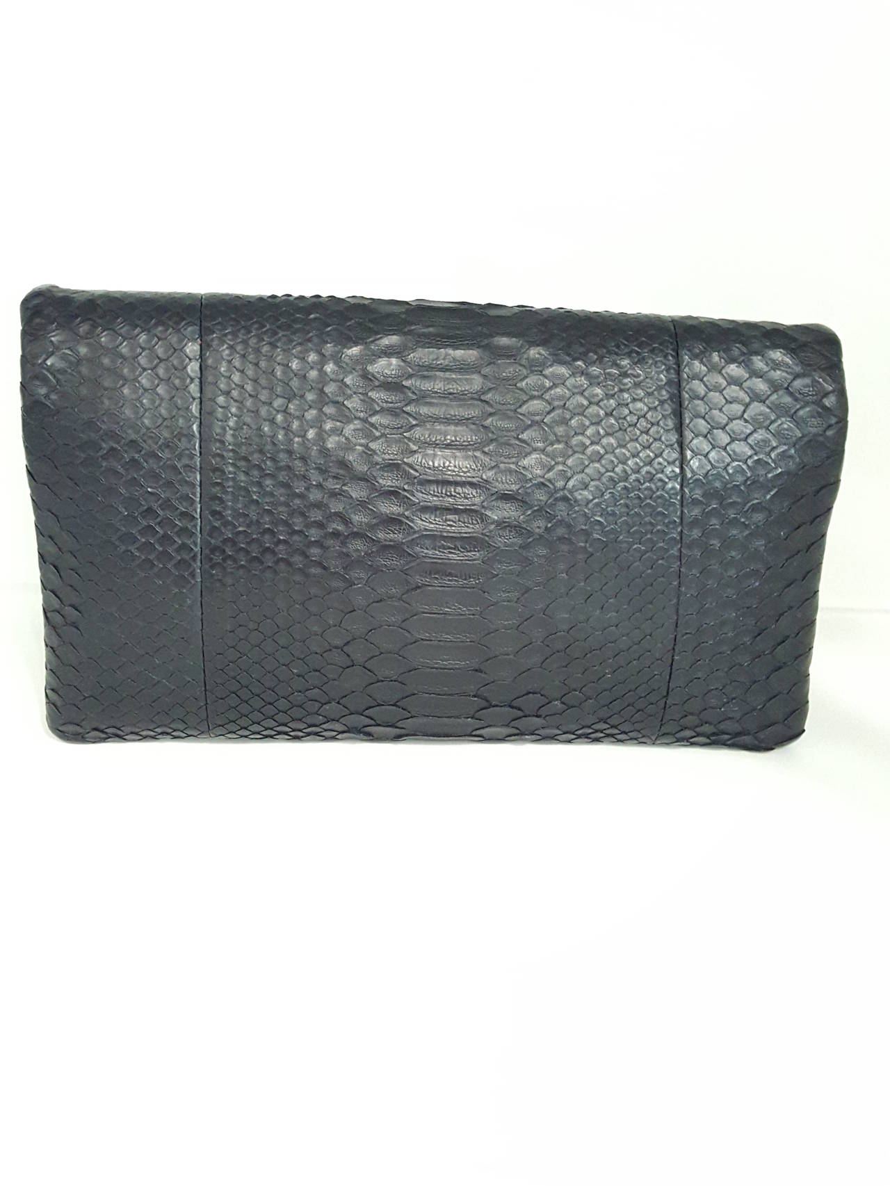 Offered for sale is a soft and supple CHANEL Black Python fold over clutch. This is Brand new and never worn.  The outside is soft Python skin and the inside is black lamb.  There are two zipper compartments.  One is 5