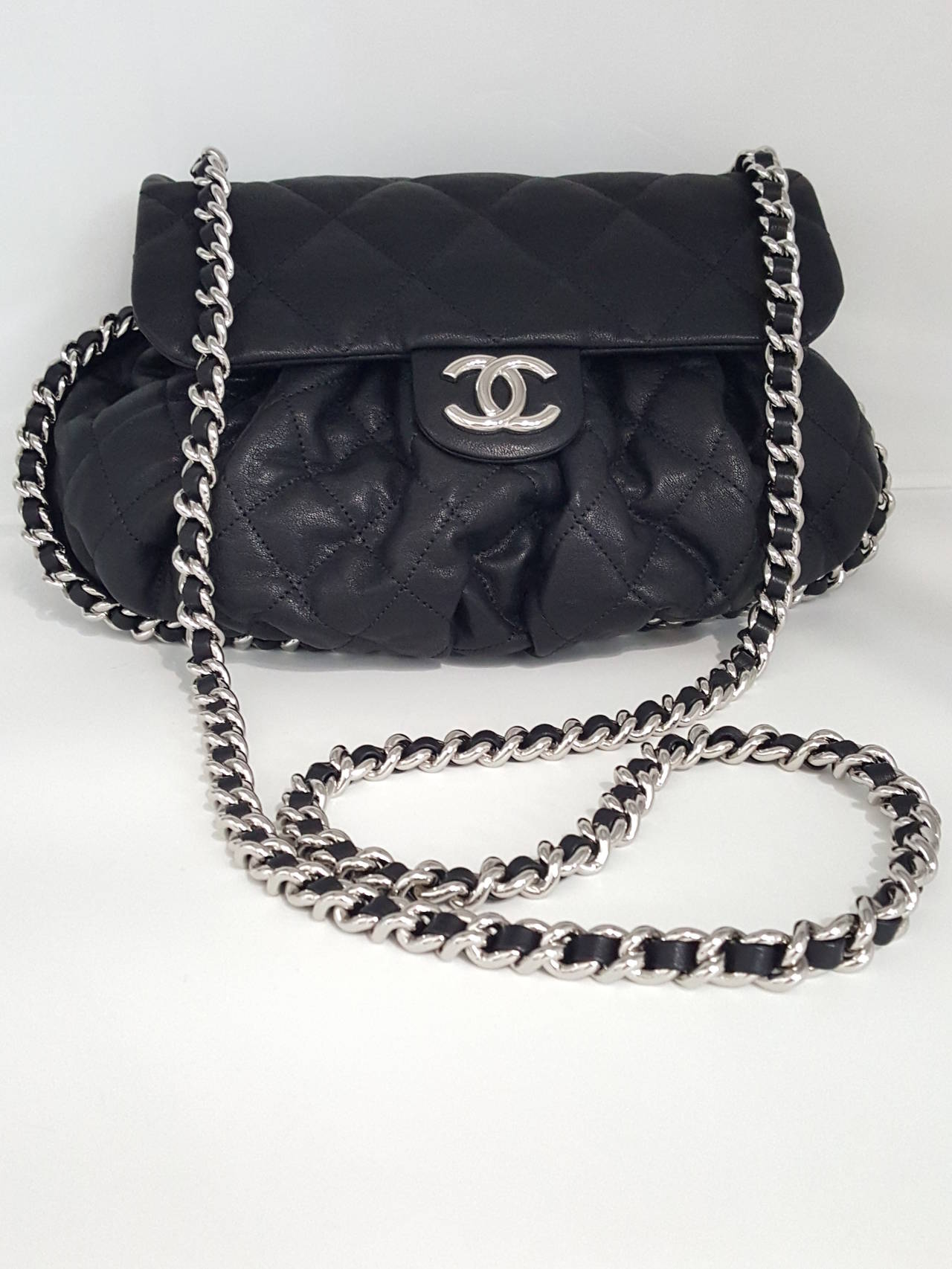 Offered for sale is this highly sought after CHANEL Medium Chain Around cross body/ messenger bag from 2015 in black aged lambskin. NWOT  This bag has silver hardware and a tan grosgrain interior with one zippered compartment.  There is a hidden