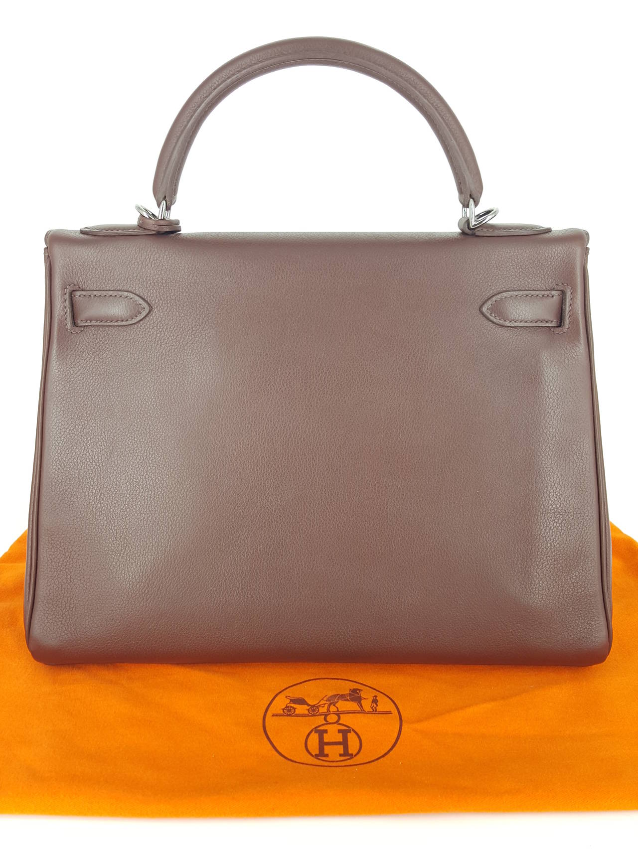 Offered for sale is a beautiful chocolate brown Hermes Kelly bag.  This one has the rare Ruthenium hardware (darkened silver).  Produced in 2005, the strap has never been used and still has original plastic on ends. Very gently carried, this bag is