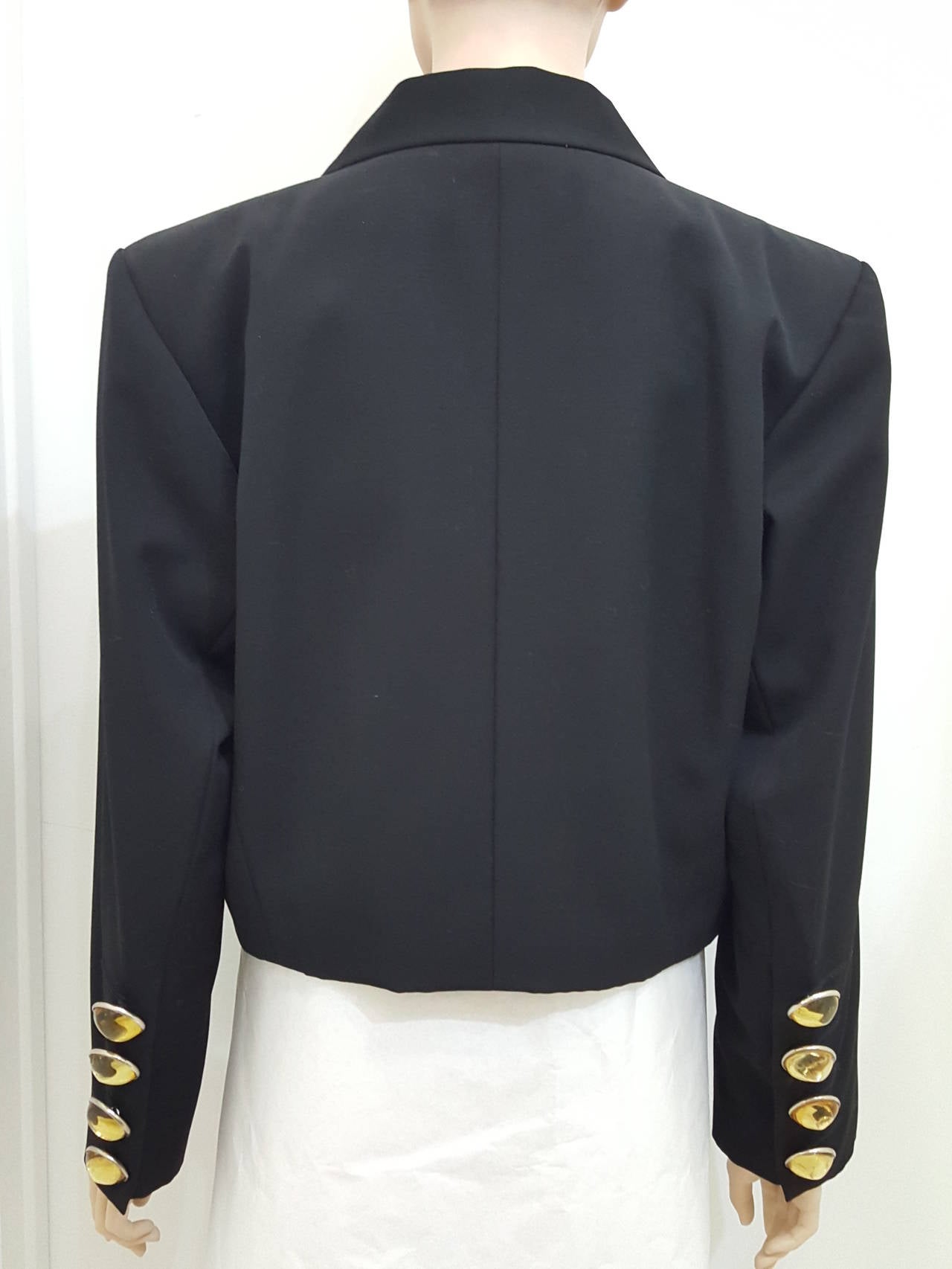 It is all about the buttons.  This fabulous vintage YSL Bolero jacket has great golden Lucite buttons down the rear of each arm.  It is from his Rive Gauche collection an is in fabulous condition. The black silk tuxedo  trim and the large buttons (1