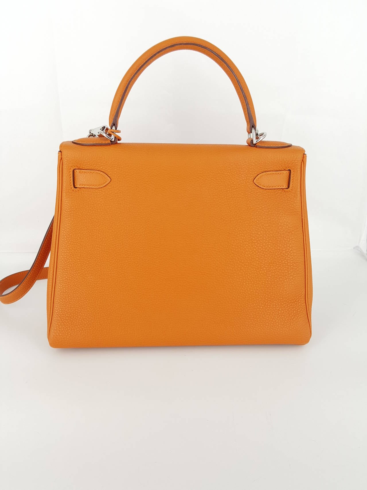 Offered for sale is this HERMES Kelly bag in orange Togo leather with silver hardware from 2007.  This is one of the iconic bags from Hermes and in a very sought after color.  This has the appearance of never been used, and there is still plastic on