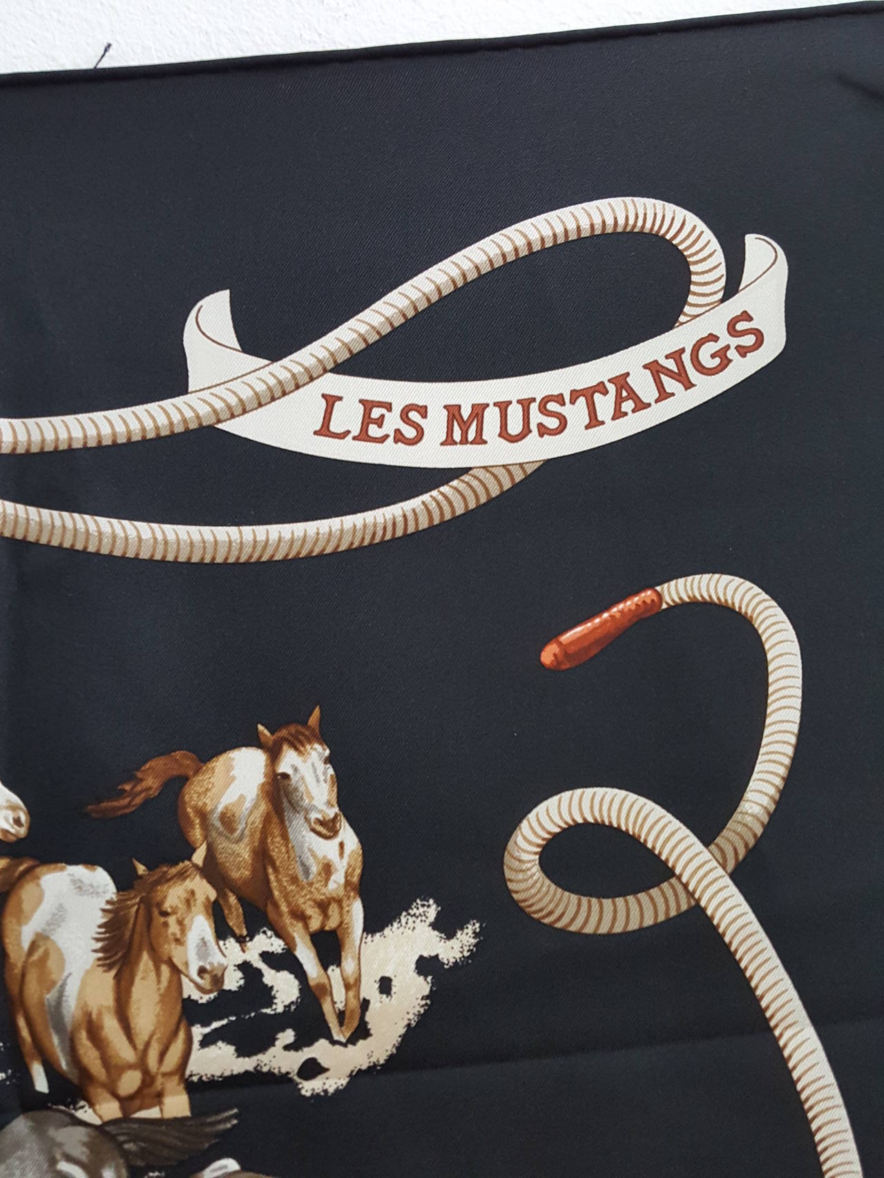 Offered for sale is this lovely Hermes scarf by Robert Dallet from 1993/1994 in 
black, rich brown, and white with the colored cowboys in blues and green.The mustangs are depicted beautifully and the added colors make the scarf come to life.

90