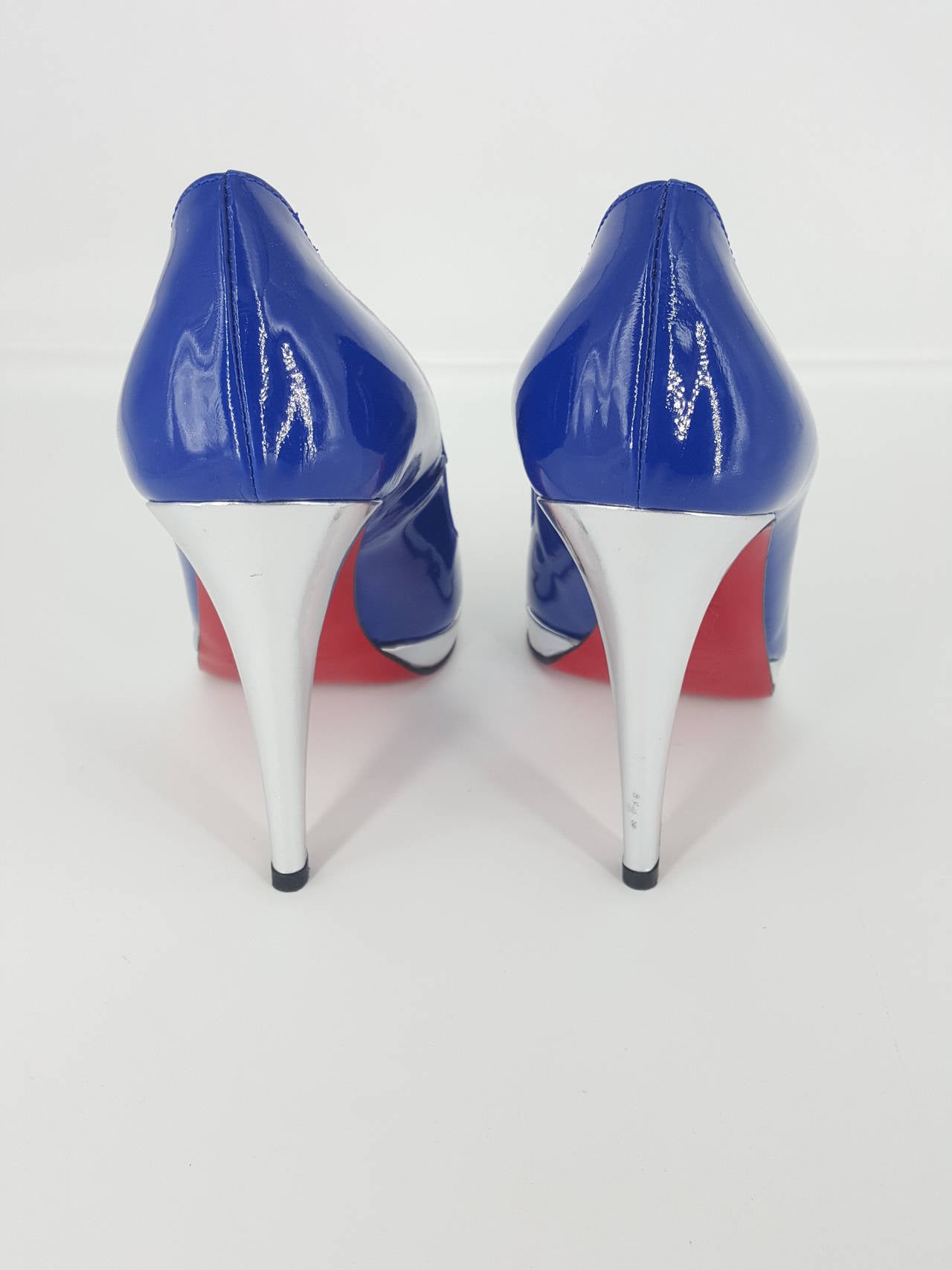 Offered for sale is a pair of Christian Louboutin platform pumps in a fabulous cobalt blue and silver with a silver heel.  These are closed toe with a 1/2