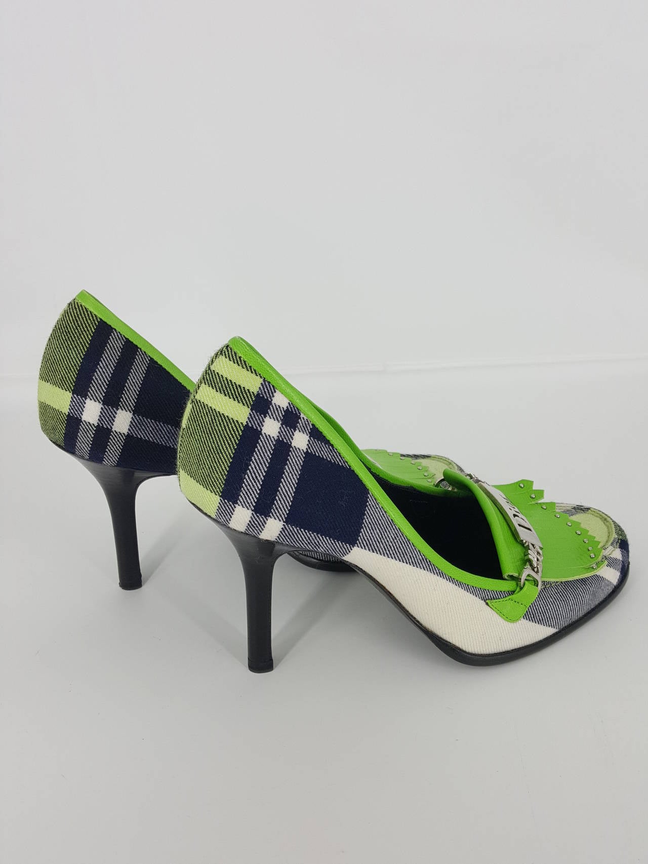 Offered for sale are these new never worn Dior pumps in lime green, navy and white plaid flannel.  They are darling.  The large silver Dior charm on the front and the fringed lime green leather dive it a Scottish flavor.  Great with jeans or  a