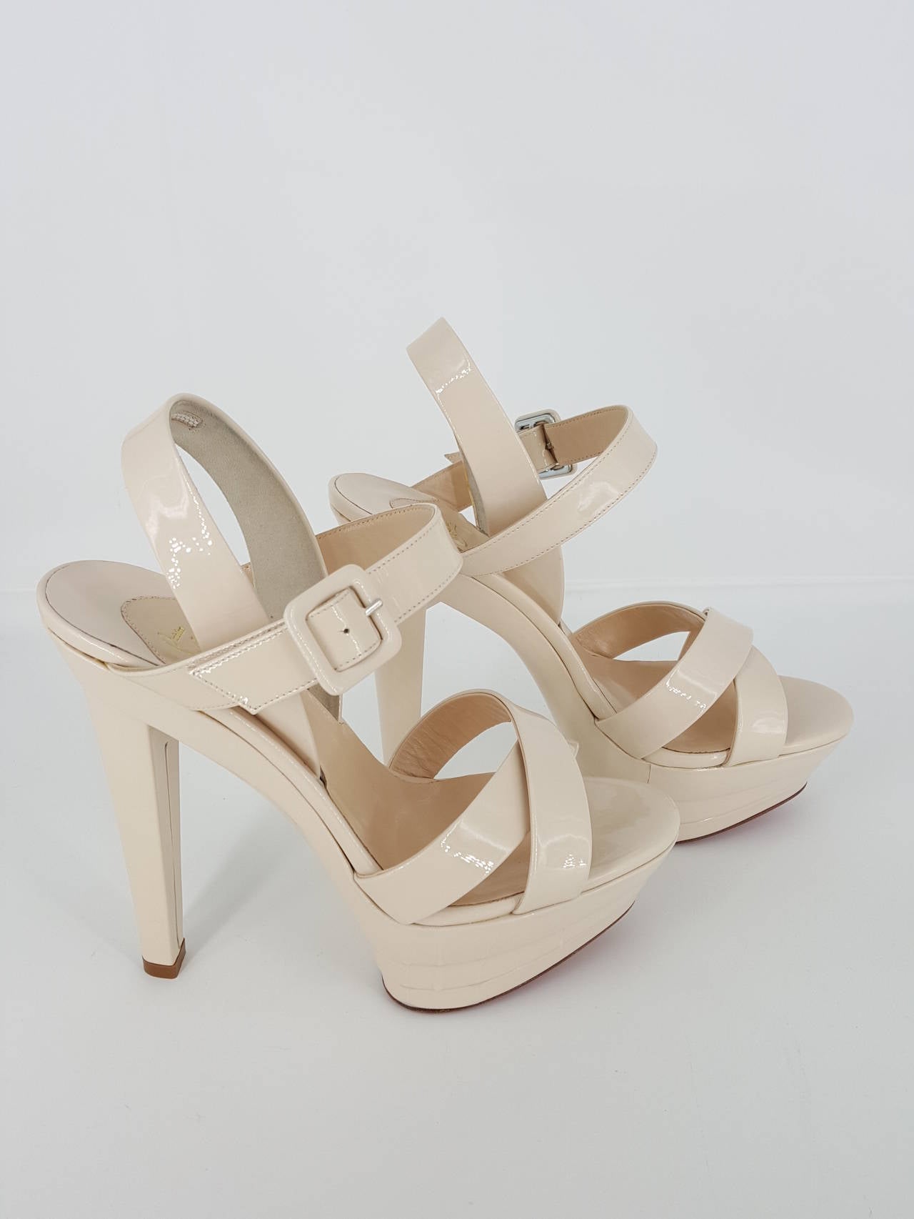Offered for sale are these lovely Christian Louboutin bone patent leather strappy Platform high heels which have never been worn in size 37 or 6 1/2.  These infamous red bottoms have a 