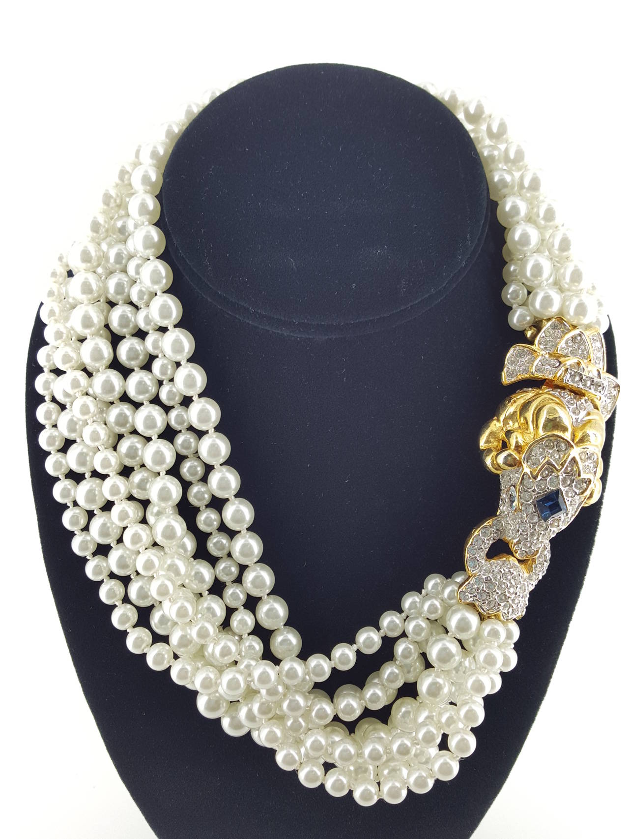 Offered for sale is this beautiful KJL crystal embellished Rams Head necklace with 8 strands of white simulated pearls.  The rams head is gold plate with clear crystals and a dark blue sapphire crystal in the center. Truely one of his Fantastic