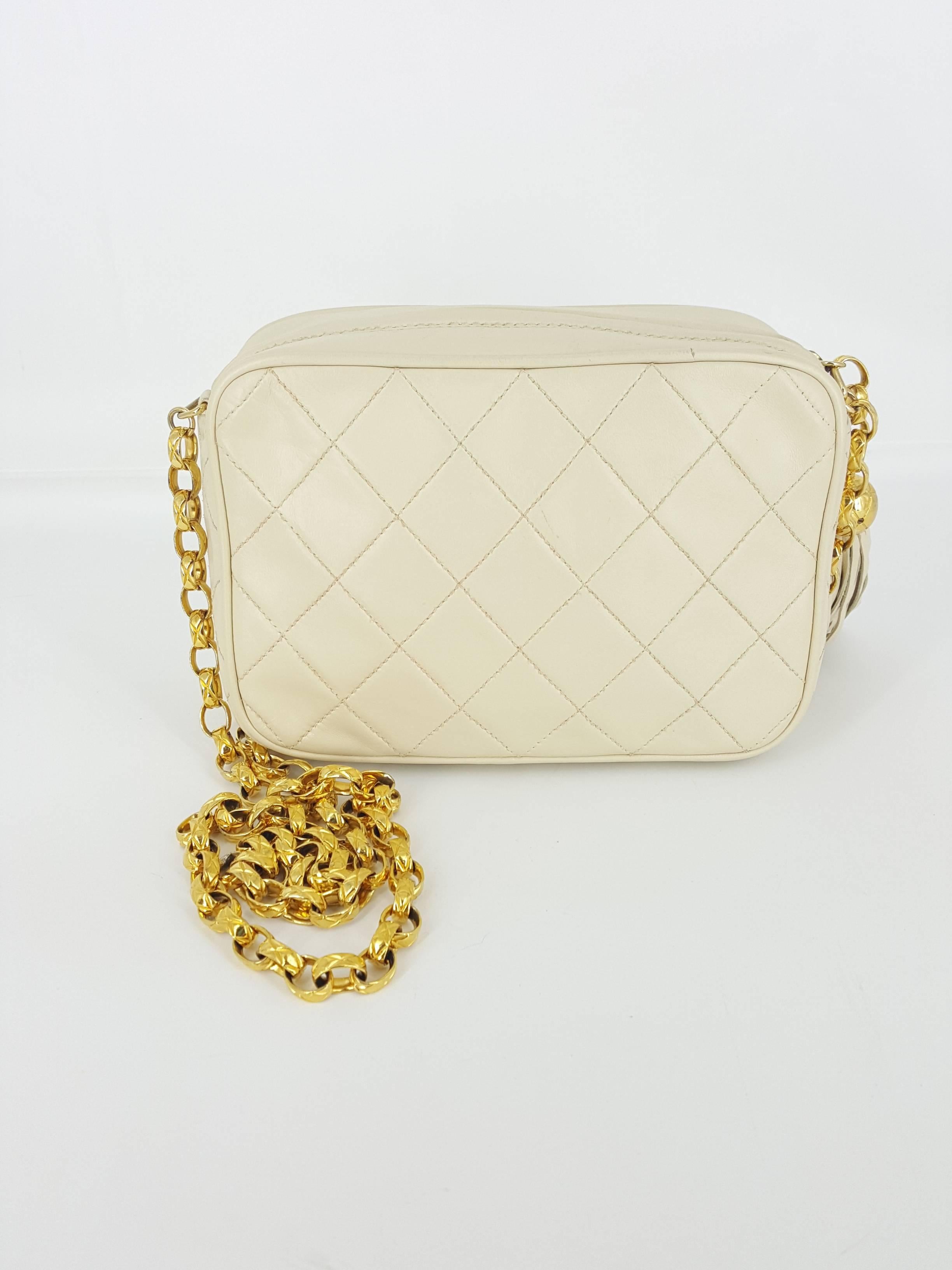 Offered for sale is this beautiful cream colored lambskin Chanel camera bag with long tassel and gold hardware.  The 20 1/2