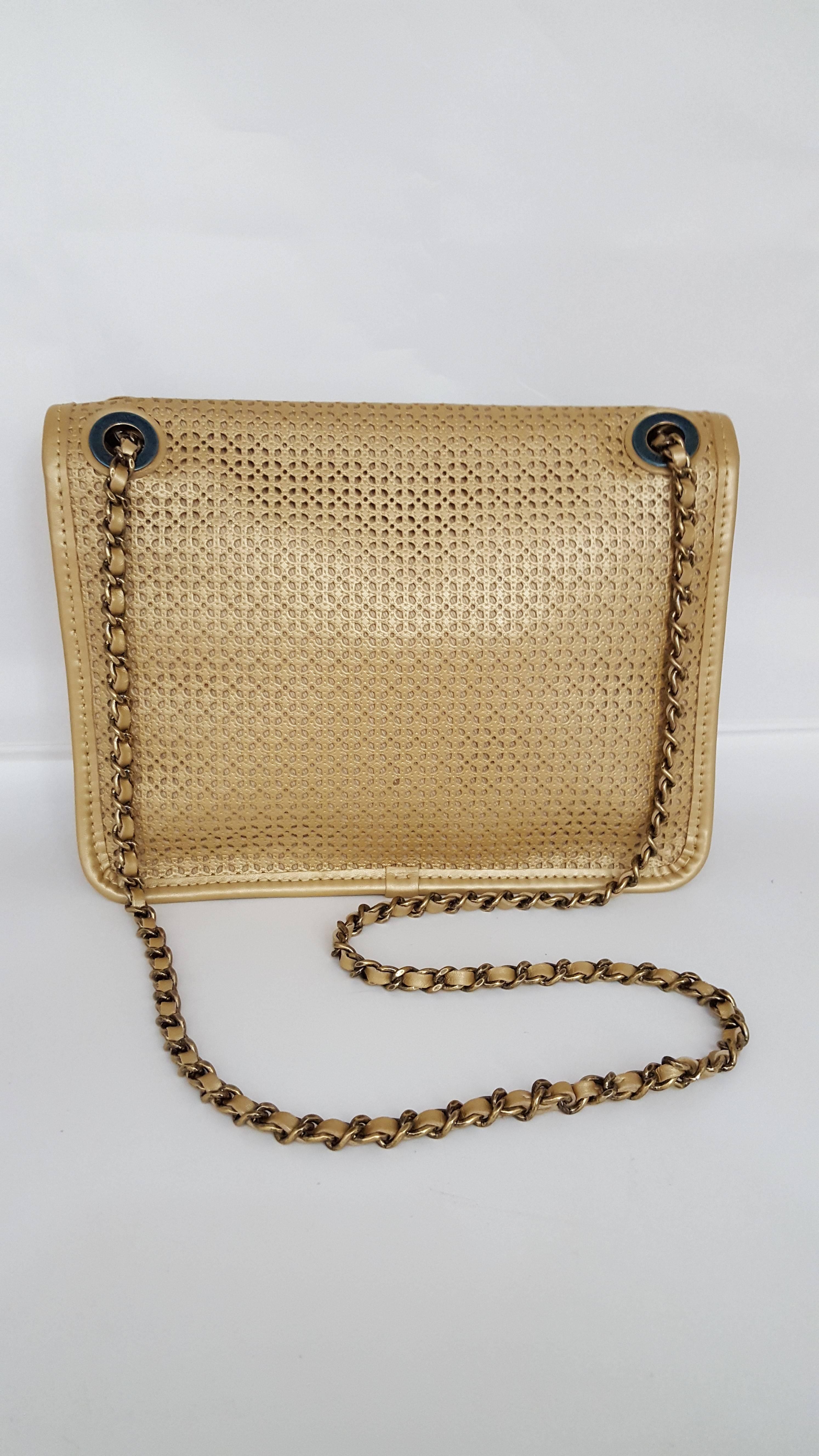 Offered here is a rare Chanel shoulder bag from the Dubai Collection 2015 and was never used.   The beautiful metallic beige color with the antiqued gold hardware is stunning.  On the shoulder chain is a double sided medallion.  One side is CC and