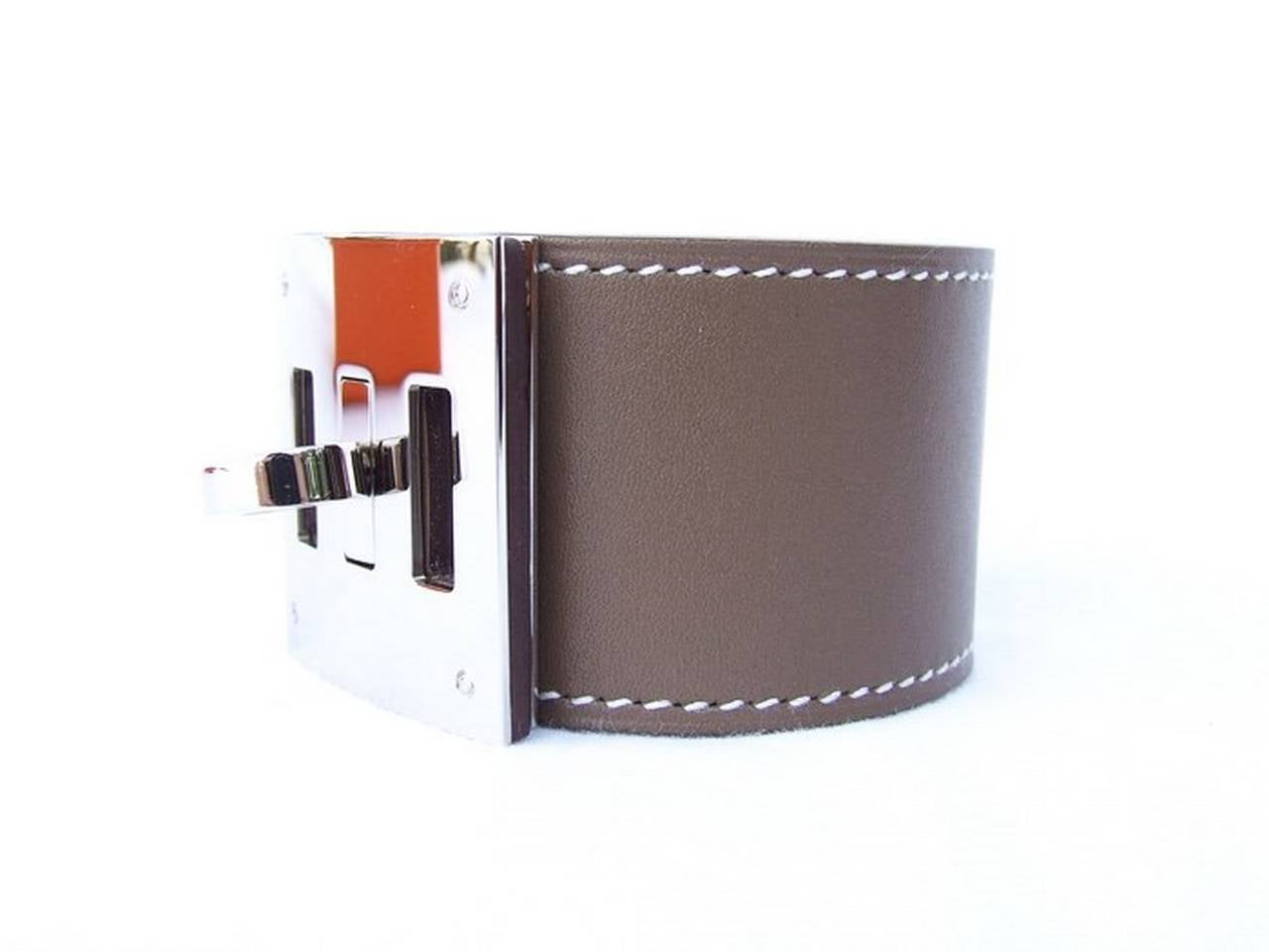 BEAUTIFUL AUTHENTIC HERMES BRACELET
 
KELLY DOG

Made In France, stamp Q

Made of veau tadelakt leather

Colors: Etoupe (light brown) leather, white stitching, Palladium (silver tone) hardware

Length (hardware included): 19,7 cm (7,76