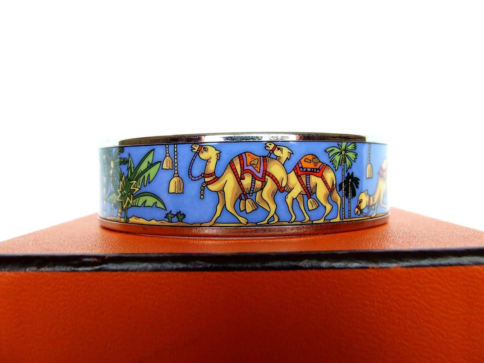 RARE AND BEAUTIFUL AUTHENTIC HERMES BRACELET

Pattern: Camels in Desert

Made in Austria 

Stamp E for 2001

Made of Printed Enamel and Palladium Plated Hardware (Silver-tone)

Colors: Blue Background, Beige Camels and Green Palm