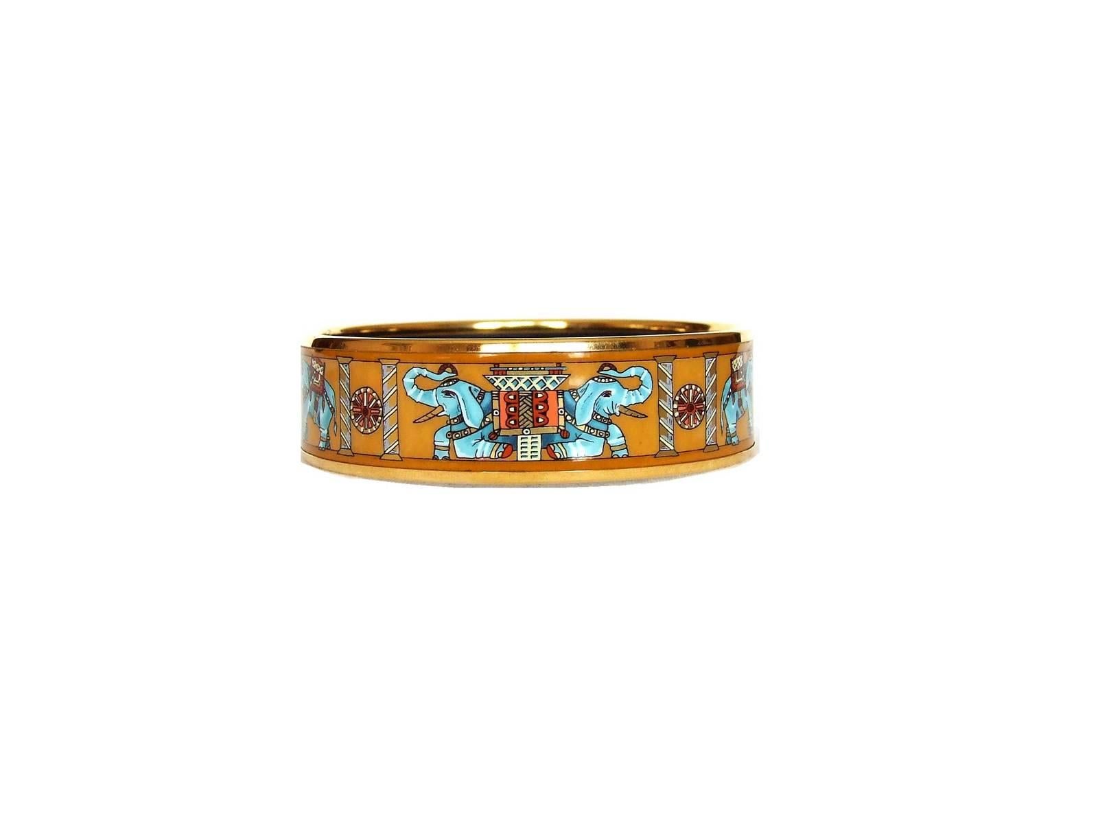 GORGEOUS AUTHENTIC HERMES BRACELET

Pattern: Torana (Elephants)

Made in Austria +Z

Made of Enamel Printed and Gold Plated Hardware

Colors: Yellow Background, Turquoise Blue Elephants, Gilded columns. Inside is black. 


