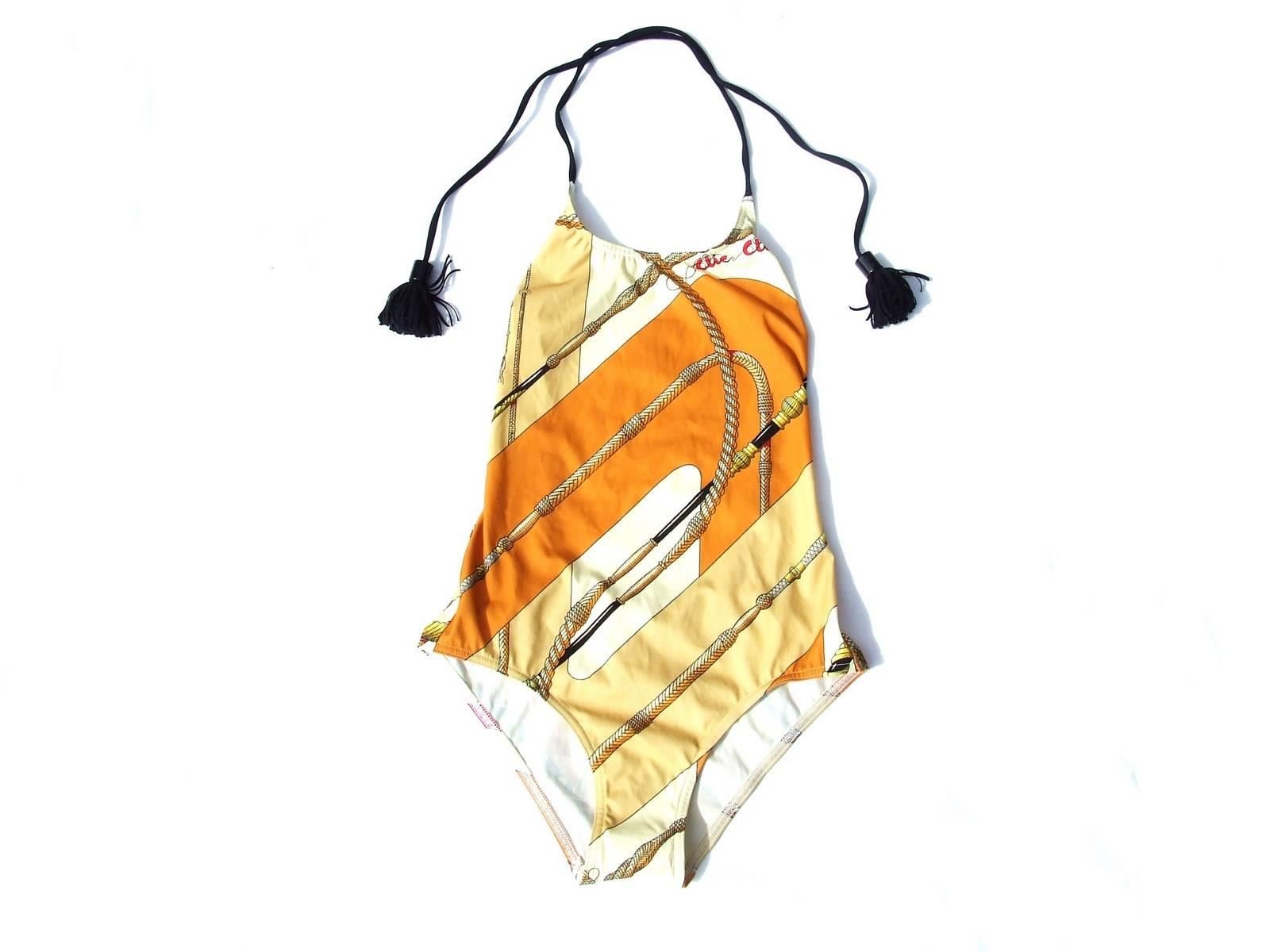 Beautiful Authentic Hermes Swimsuit

Pattern: Clic Clac

Made in France

Halterneck Swimsuit, 1 piece

Made of 62% polyamide and 38% elastane

Colorways: Orange, Beige, Black

closes by 2 links to tie around the neck

Size: