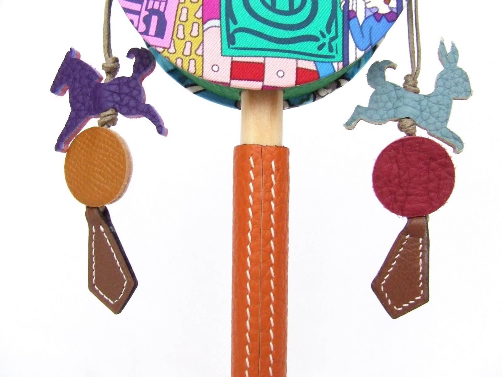 GORGEOUS and RARE Authentic Hermes Rattle

Cutest Tambourine ever !

Made of silk-covered rounds, small leather animals and a wooden handle covered with leather

The small charms are made in different leathers and colors and are lined

Colorways: