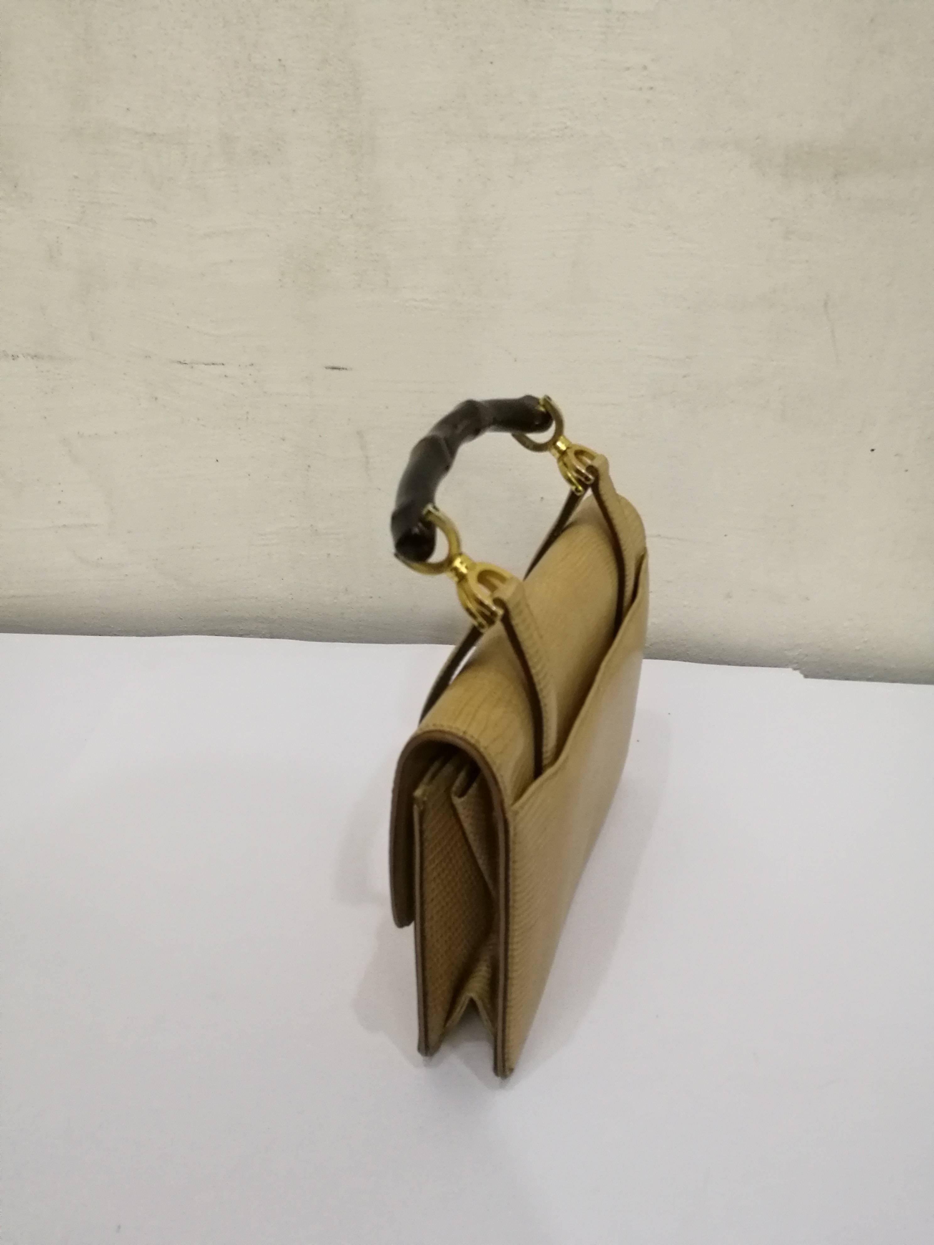 Borsa Gucci in lucertola e bambù del 1960
Hardware in tonalità oro
Pelle di lucertola tono Beije
Manico in bambù marrone
Lunghezza totale con manico in bambù: 25 cm