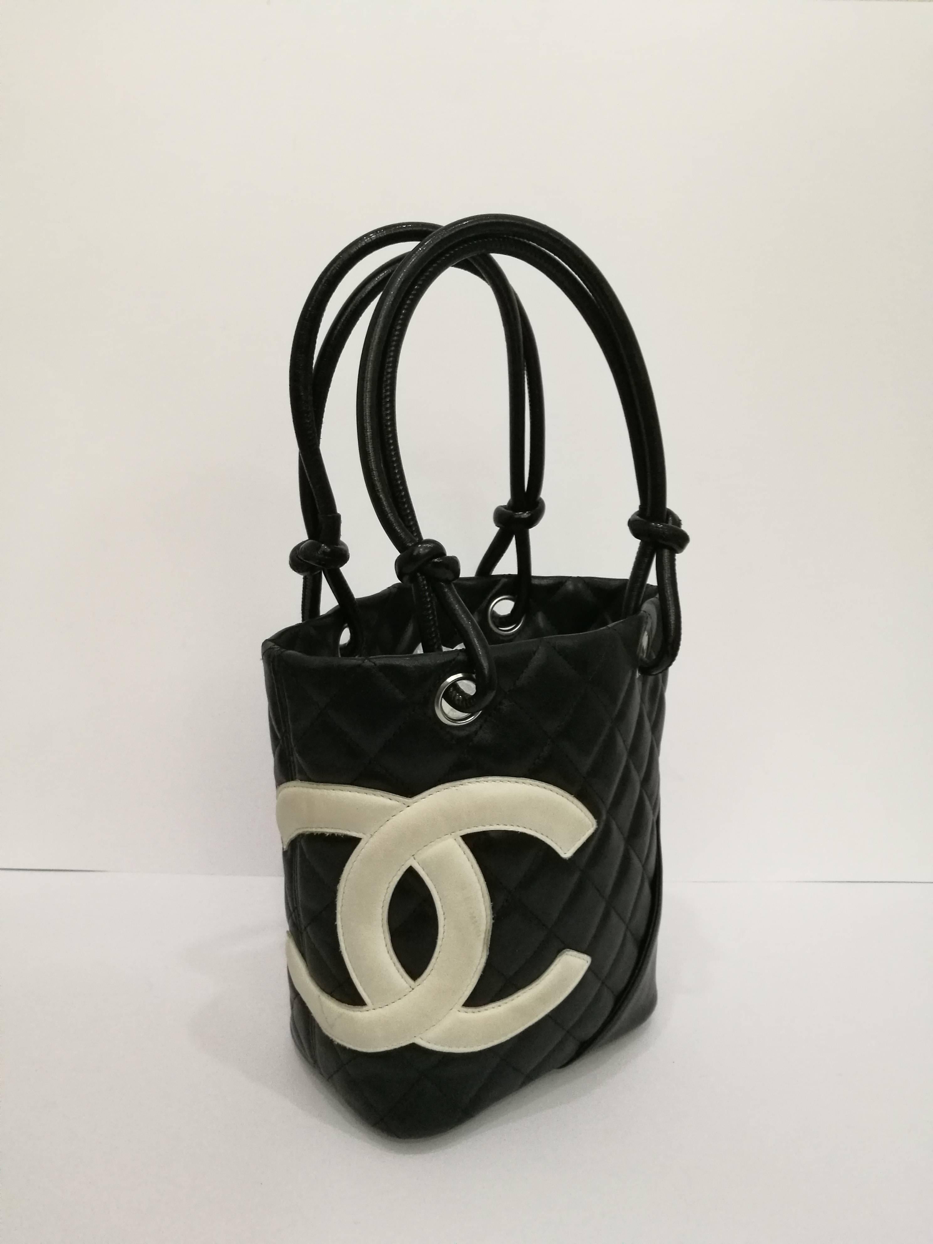 Chanel Black white logo Cambon bag
Black leather white logo leather handle / shoulder bag by Chanel
Inside fucsia colour textile with signs of use
Total lenght with handle 35 cm