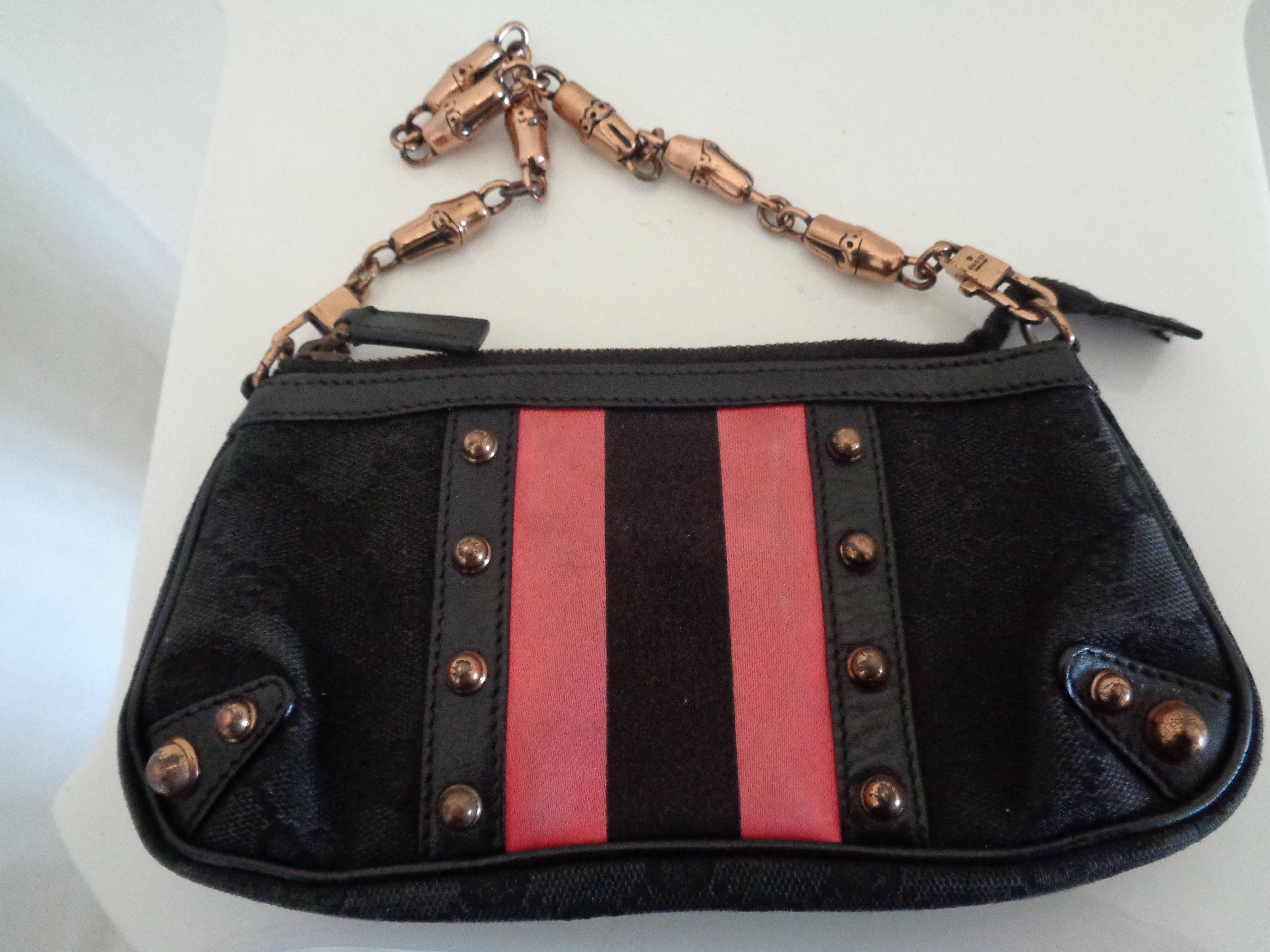 Gucci black Canvas GG fucsia bamboo chain Shoulder Bag
Black GG canvas clutch with pink satin striped accent, rose gold hardware, interior patch pocket, bamboo motif chain 