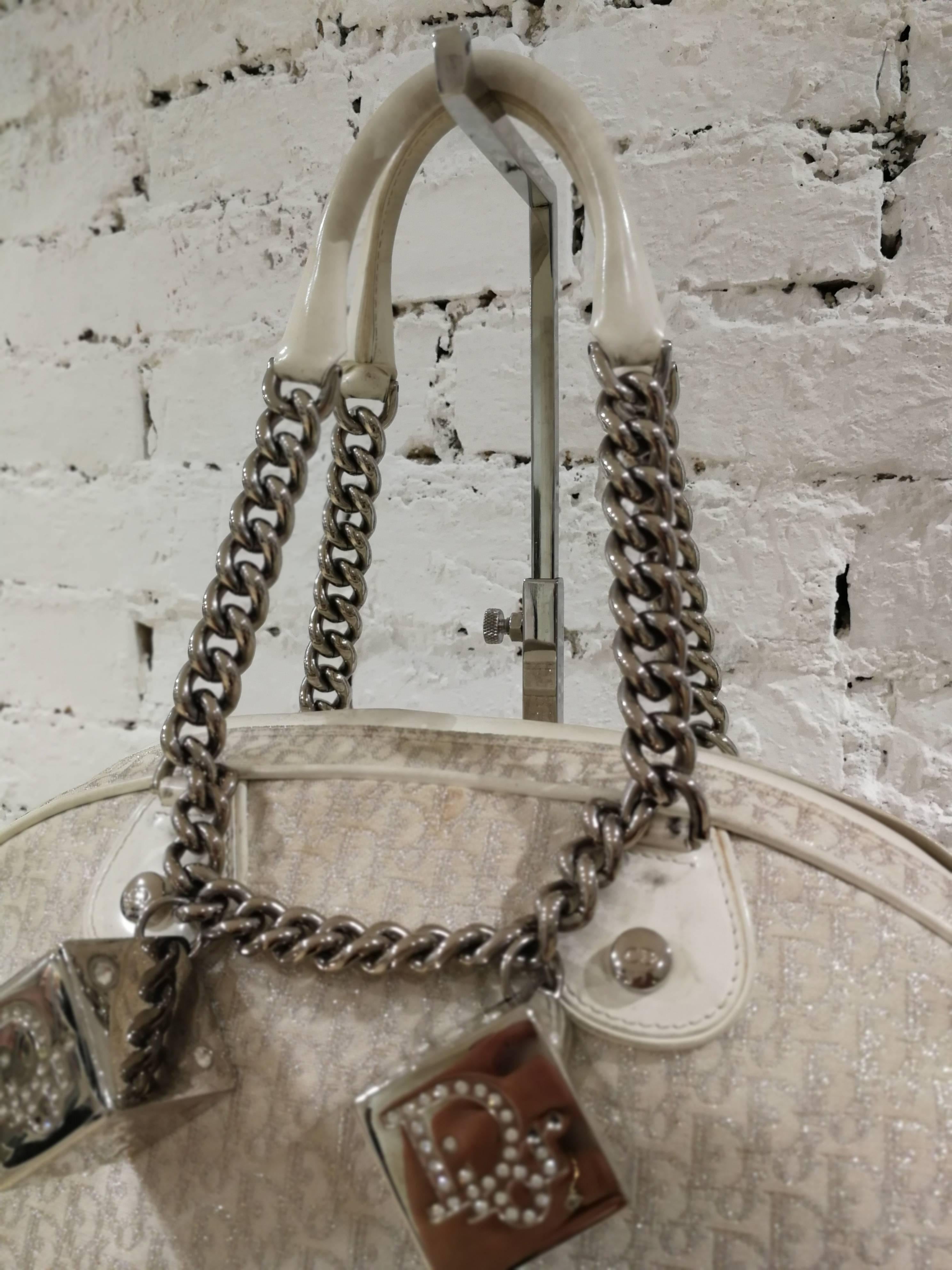 Christian Dior Gambler White and silver Monogram bag embellished with silver tone cubes missing sone of the crystal swarovski. Cream and silver metallic monogram canvas handle bag with silver-tone crystal embellished logo die hardware.
Measurements: