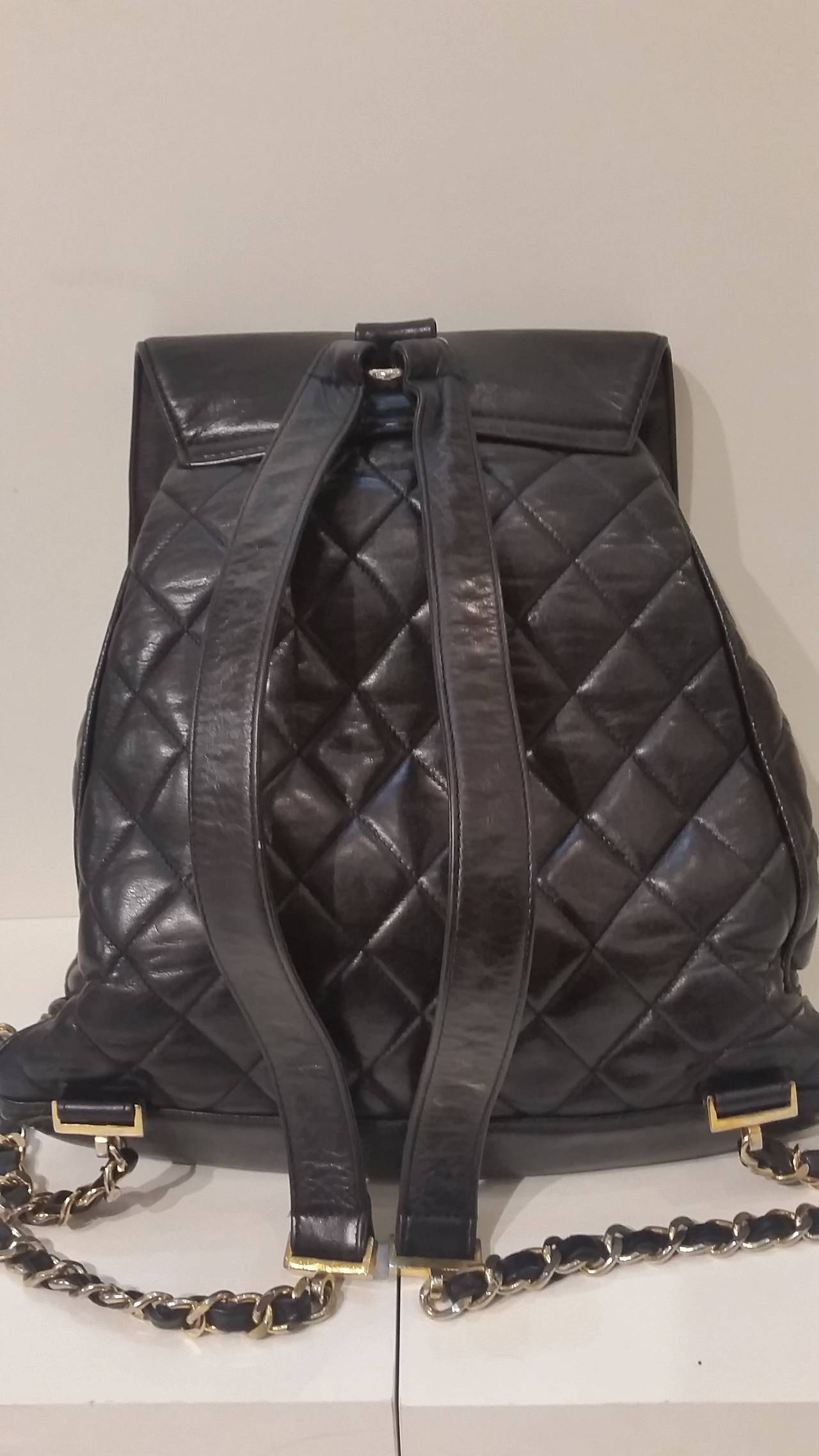 1980s Chanel black leather backpack
Black quilted leather backpack from Chanel Vintage featuring two thin shoulder straps, a fold-over frap with a gold-tone double 'C' logo plaque, a drawstring top and an interior zip pocket. Please note that