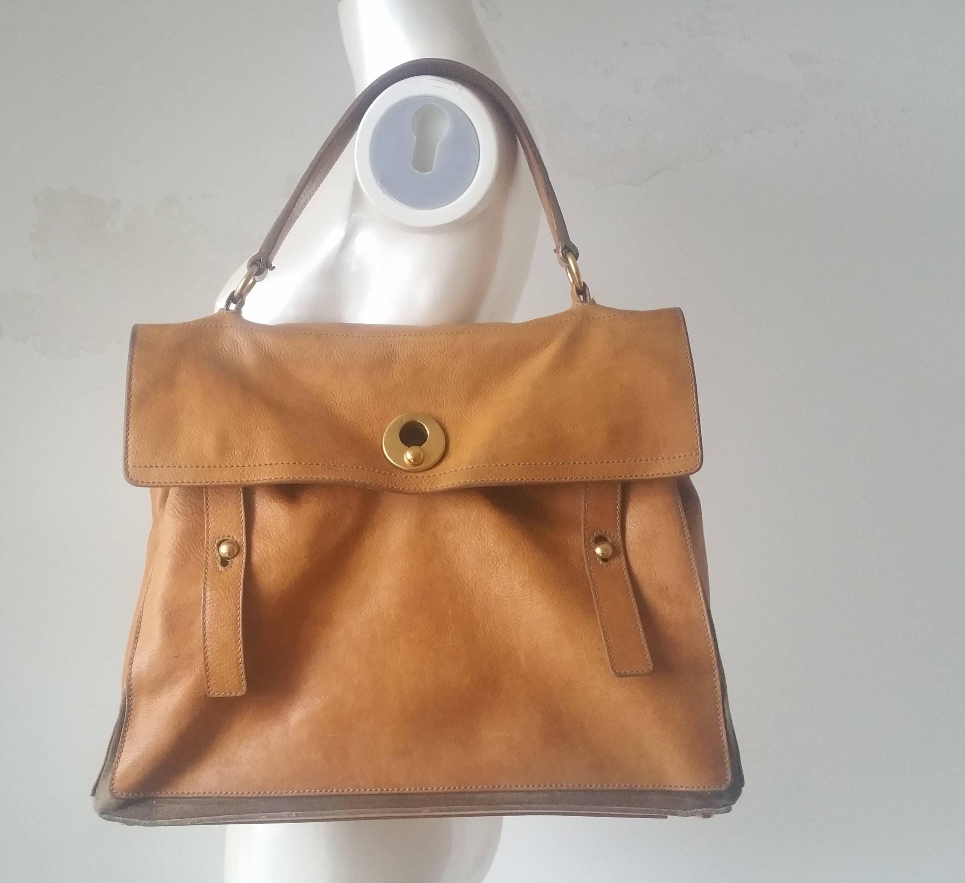 1980s Yves Saint Laurent Muse brown bag
Brown leather and canvas Yves Saint Laurent Muse Two handle bag with antiqued brass hardware, pocket at back with peg closure, dark brown woven lining, single compartment at interior with zip closure and peg