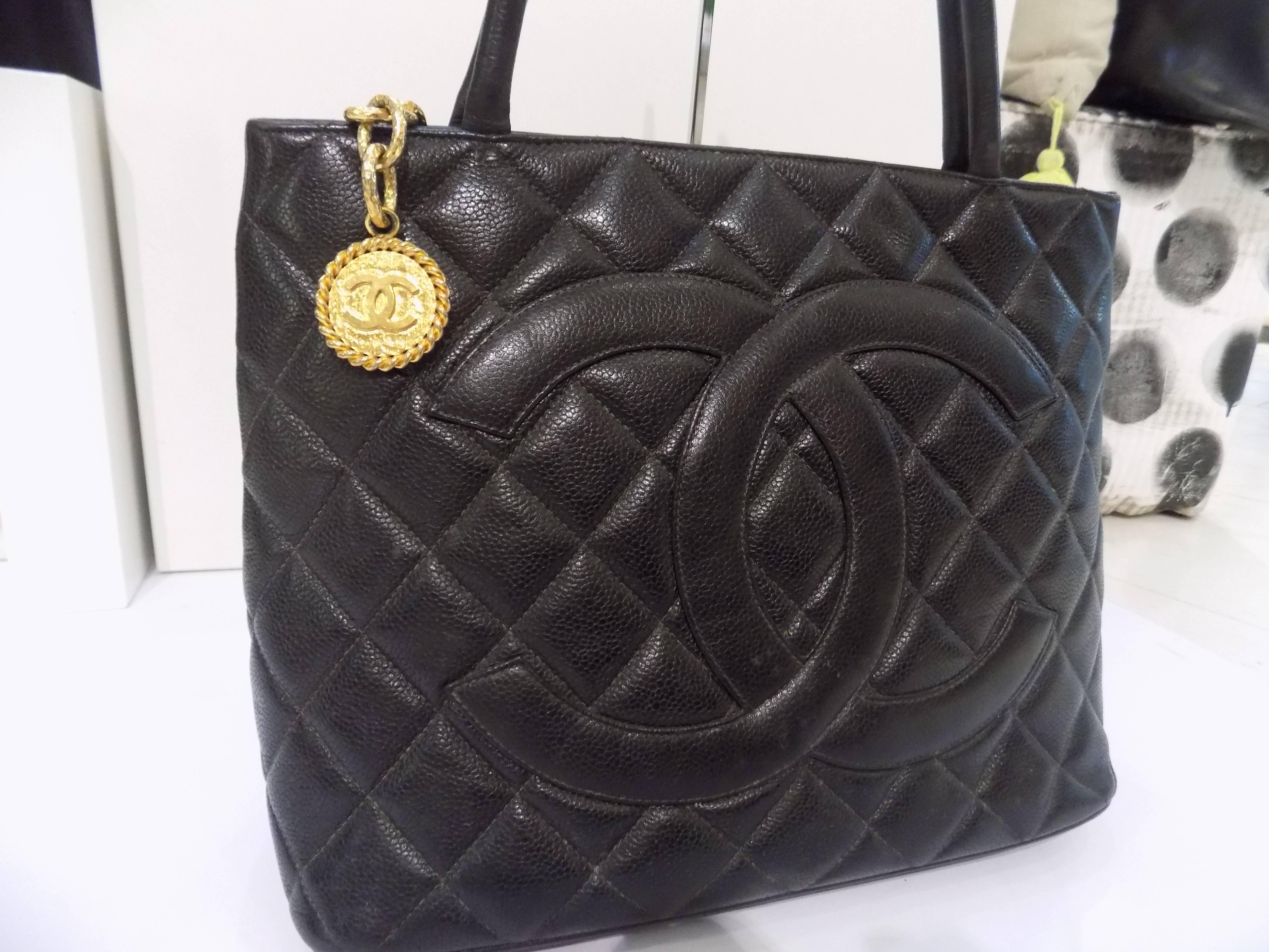 CHANEL Black Quilted Caviar Leather CC Medallion Tote Bag
Description:
Black caviar leather 'Medallion' tote from Chanel Vintage featuring round top handles, a top zip fastening, a back slip pocket, an internal zipped pocket, an internal slip