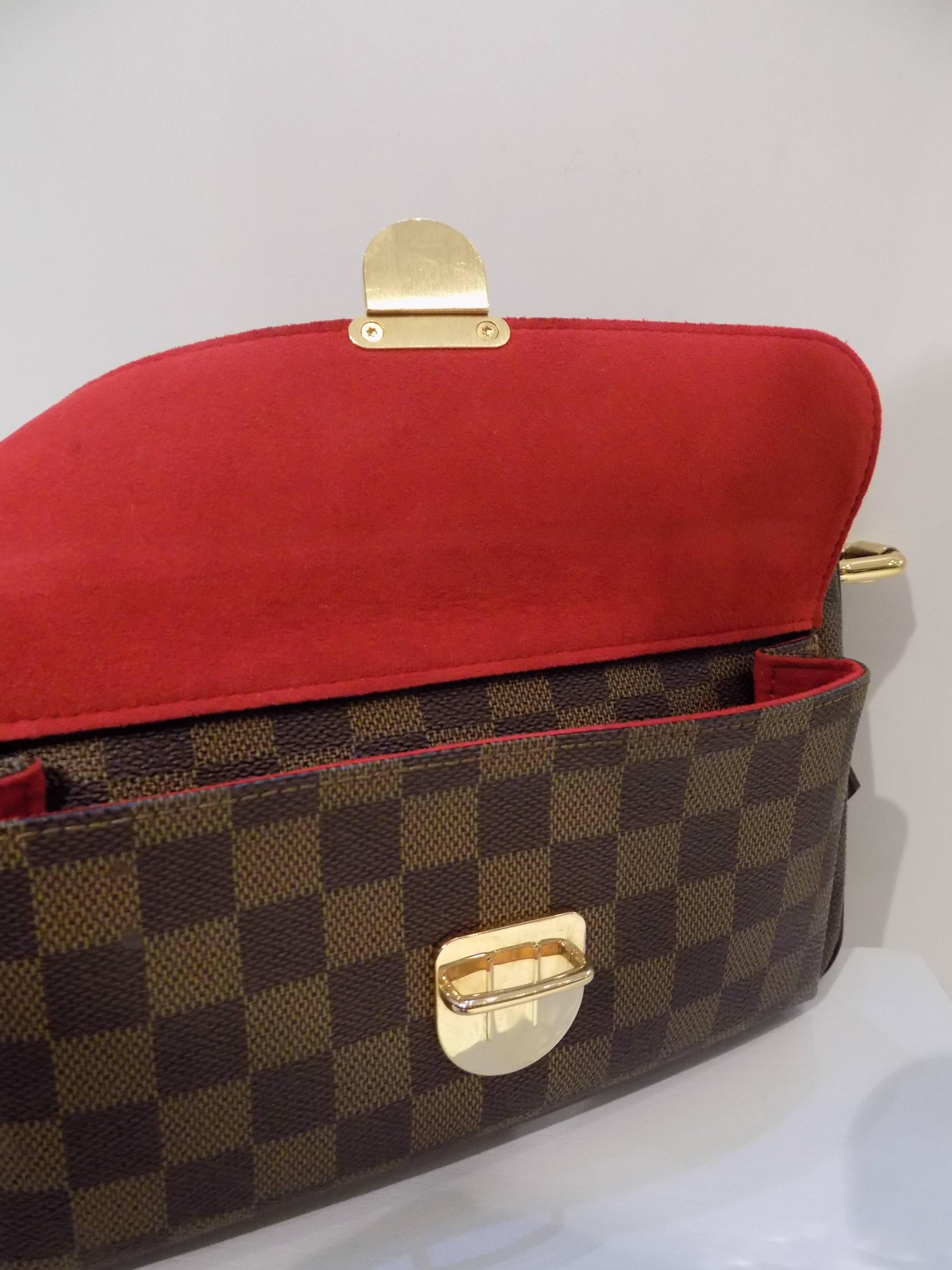 Louis Vuitton Ravello GM shoulder bag in Damier Canvas. Outside, it has 1 small pocket with flap and brass lock. Top is secured with zipper. Inside is in red alkantra lining with 1 open pocket. Comforably carried in hand or on shoulder.

Made in: