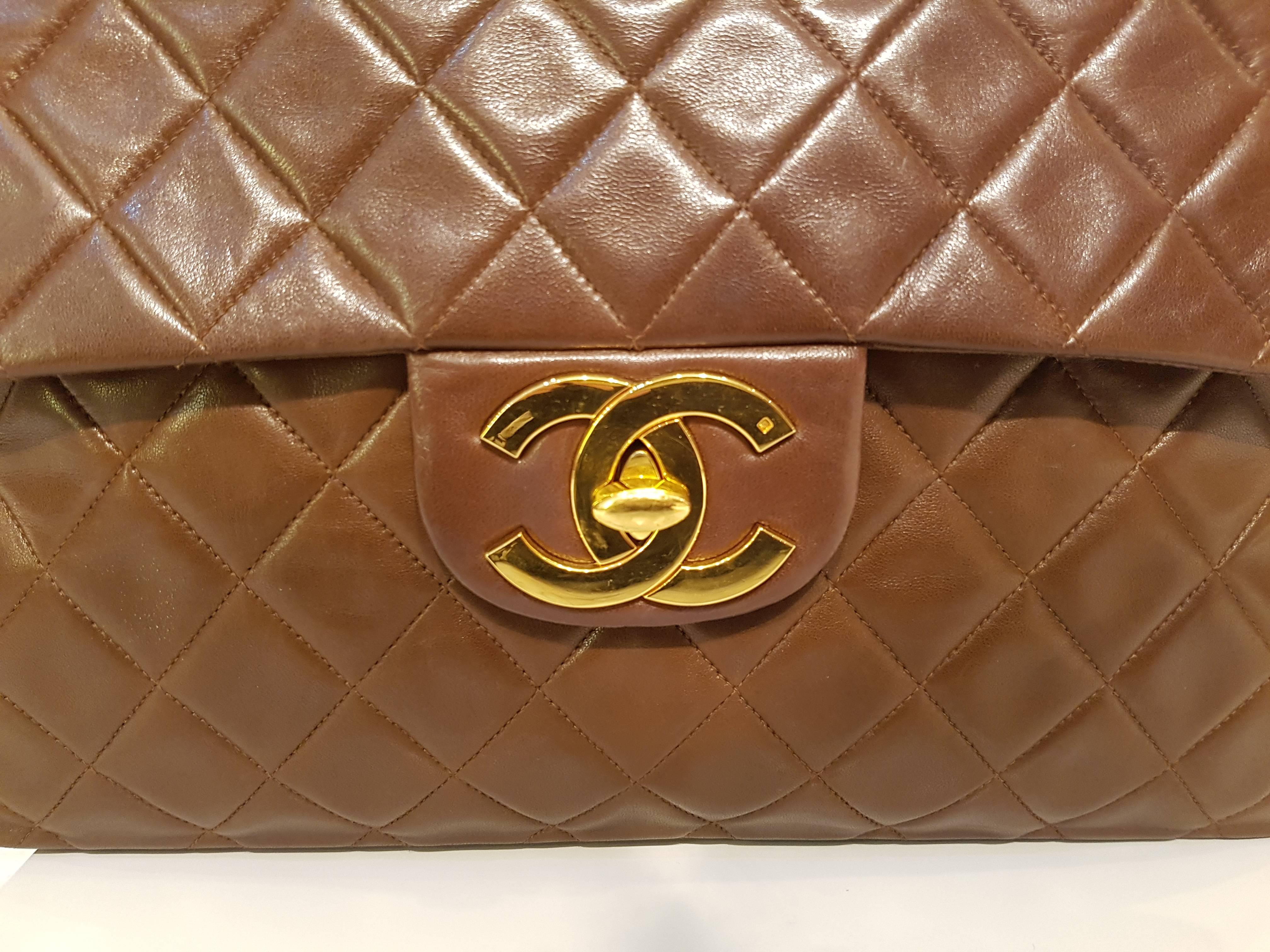Brown lambskin maxi flap bag from Chanel Vintage featuring foldover top with twist-lock closure, a chain and leather strap, a back slip pocket, an internal zipped pocket, an internal slip pocket, an internal logo stamp, gold-tone hardware and a