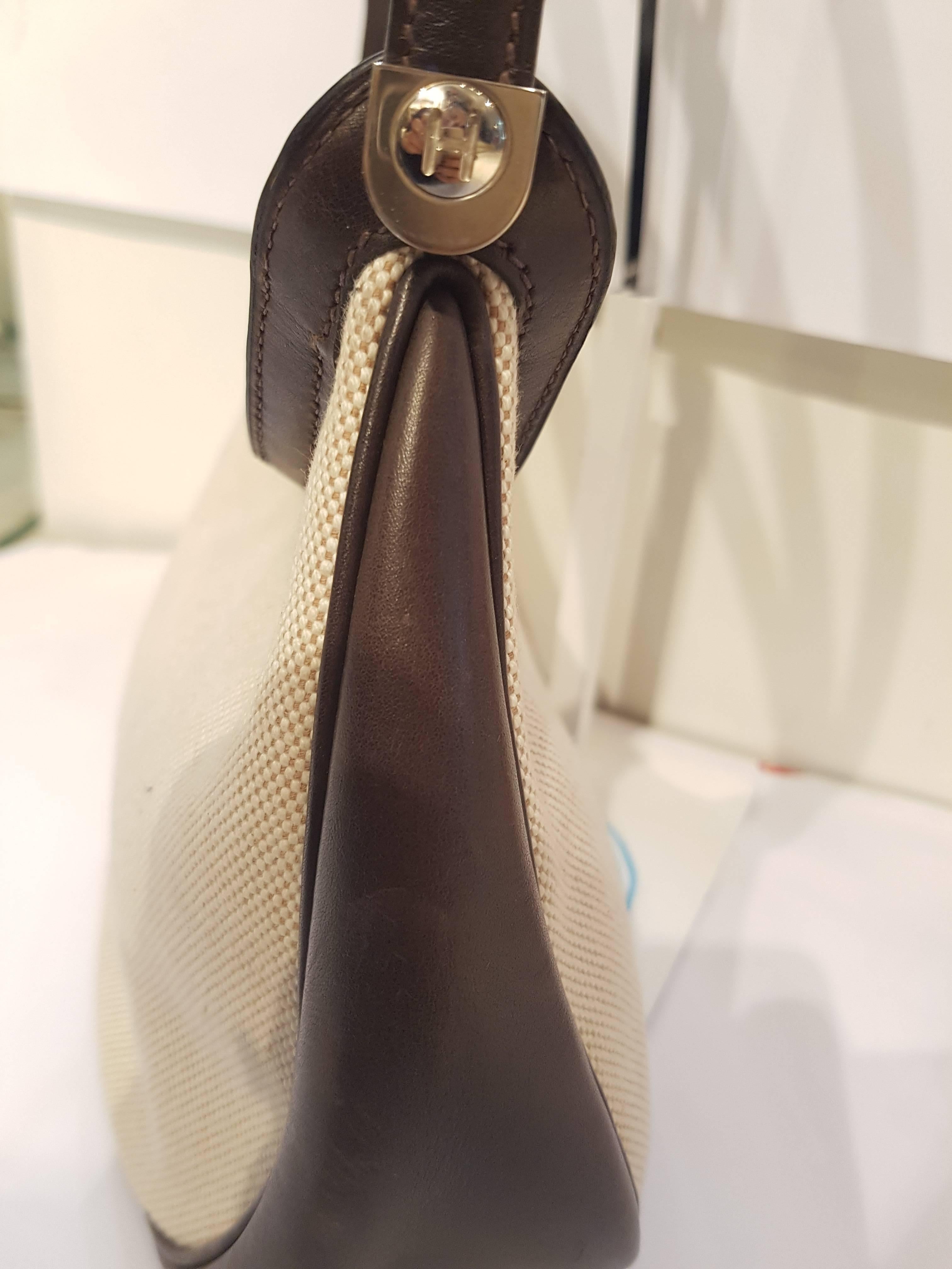 Herms Caporal brown leather cream textile shoulder bag
This stylish handbag shoulder bag is crafted of luxurious leather. The bag features a unique three tiered looping end to end shoulder strap with silver hardware. A top zipper opens to a leather