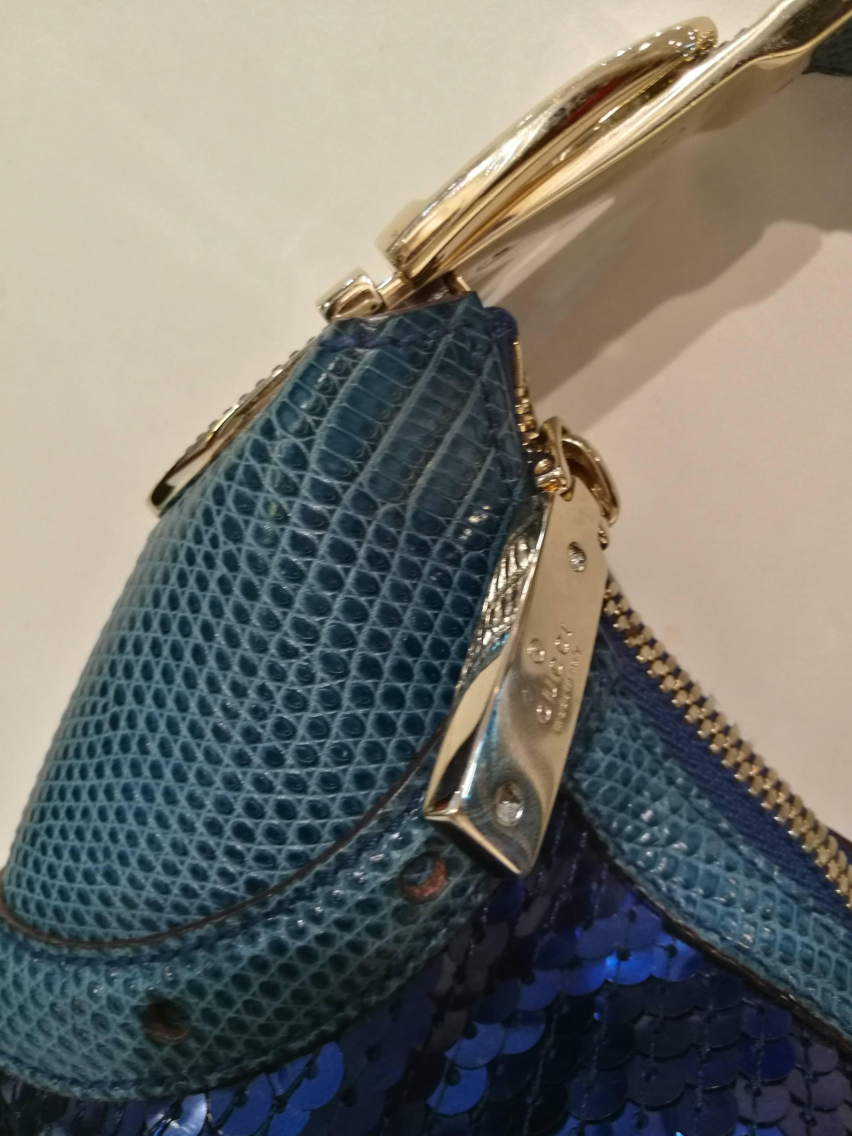 2000s Gucci Glam lizard Bag
Gucci lizard skin and blue sequin evening clutch handbag.   Features gold-tone hardware, blue lizard skin accents and trim, a single lizard skin top handle with crystal buckle (4
