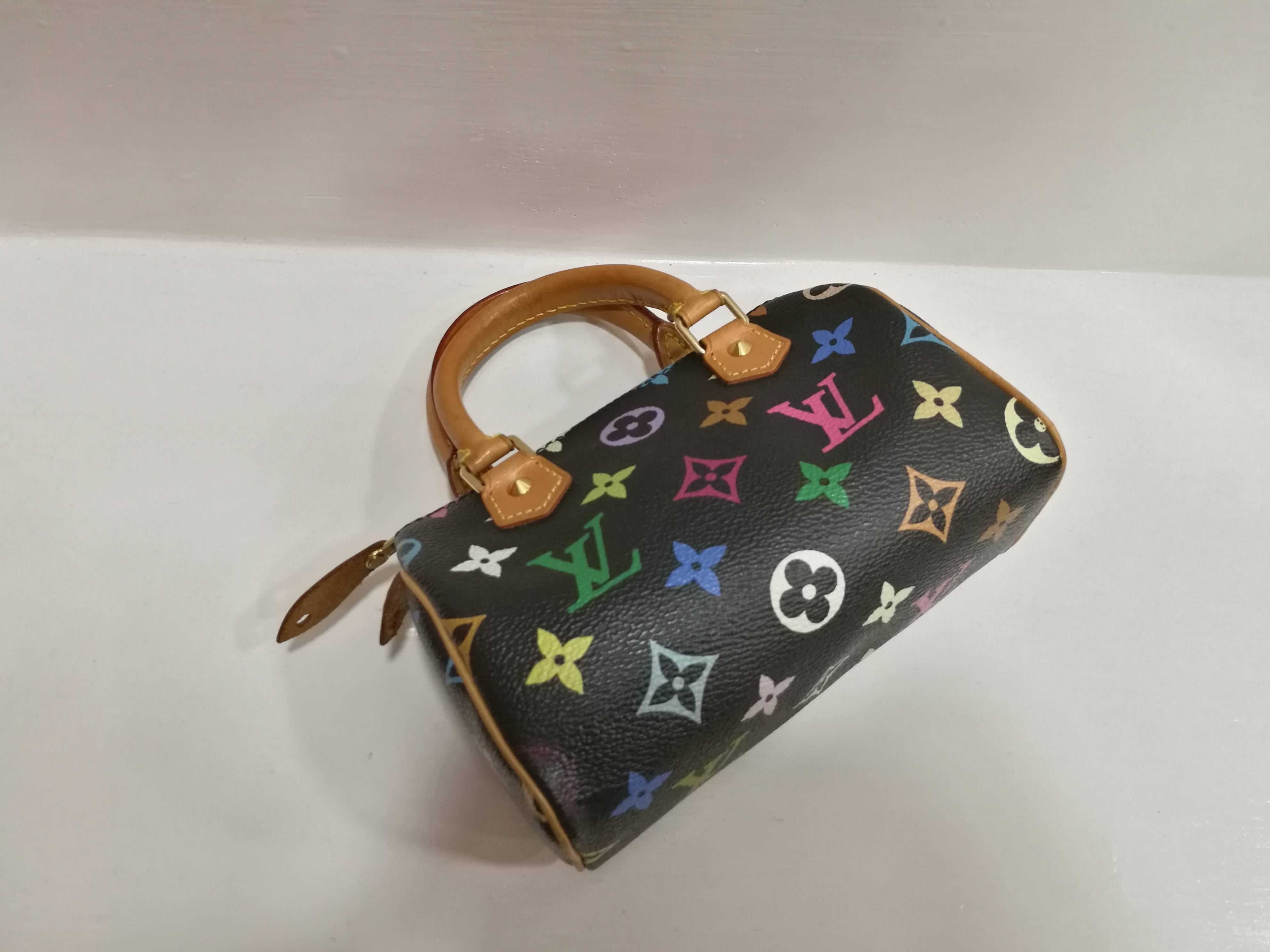 LOUIS VUITTON Multicolor Mini Sac HL Speedy Black
This chic small mini Speedy is crafted of multicolore Louis Vuitton monogram in 33 vibrant colors on black toile canvas. The bag features rolled leather top handles with polished brass hardware. The