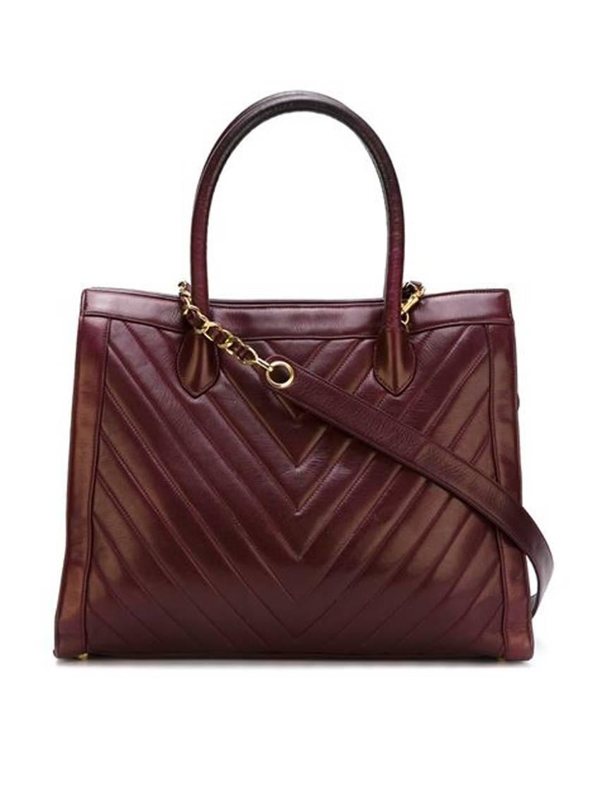 Chanel bordeaux lamb skin chevron quilted tote bag featuring a center top zipped pocket, detachable shoulder chain and leather strap, top handles, and an internal logo stamp. 
Marked Chanel. 
In excellent vintage condition. Made in France.

We