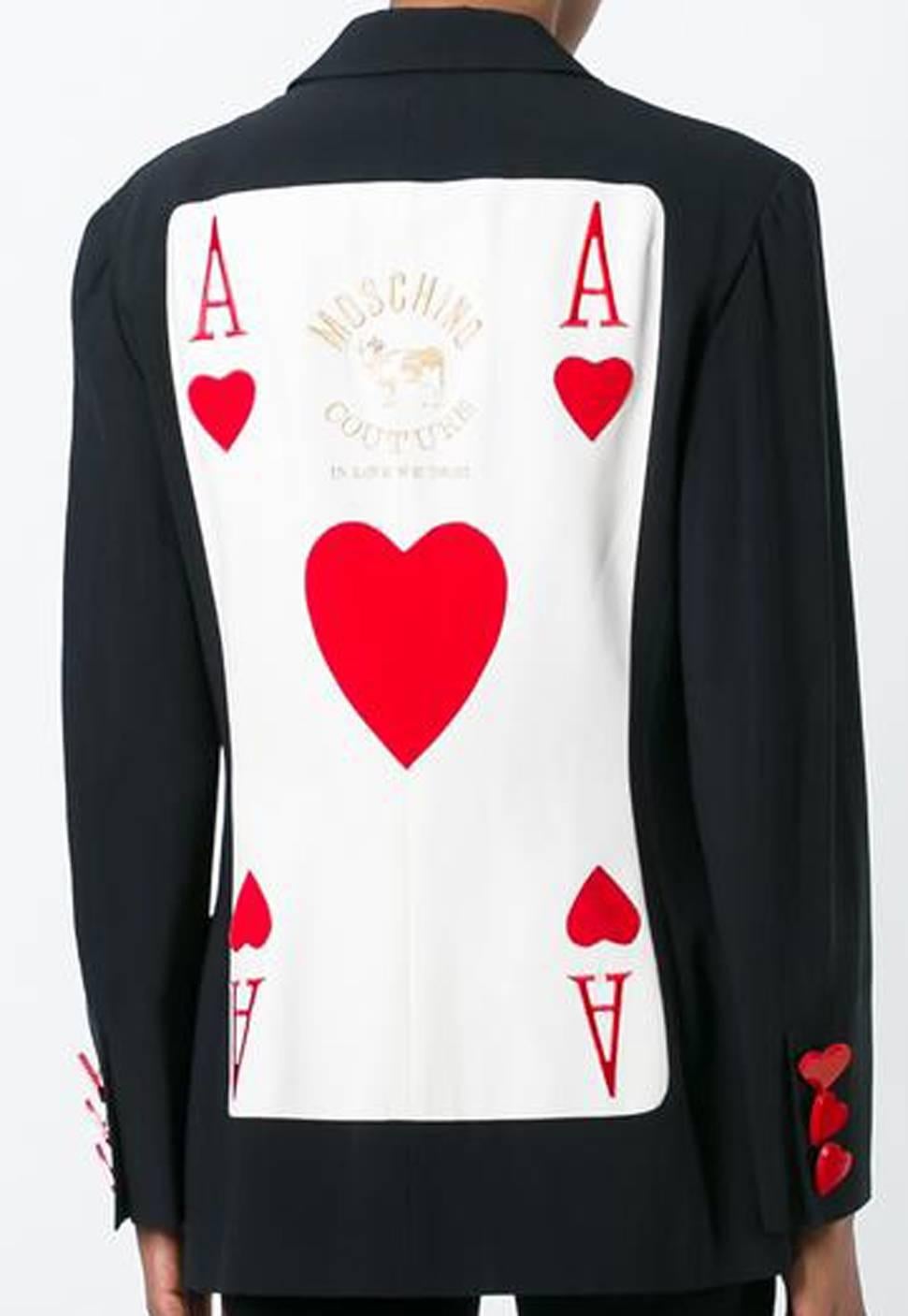 Moschino Couture black Ace of hearts blazer featuring notched lapels, long sleeves, red hearts buttons, a large Ace of hearts card detail at the back and a straight hem.
In excellent vintage condition. Made in Italy.
Estimated size: 42FR
We