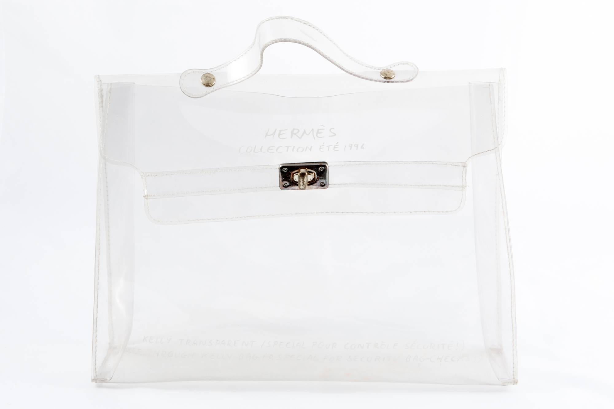  1996s Collector Hermes transparent plastic bag shaped as a Kelly bag featuring an hardware in gilt silver tone metal, simple handle in transparent vinyl allowing the bag to be worn in the hand. A special bag for security-check.
In good vintage