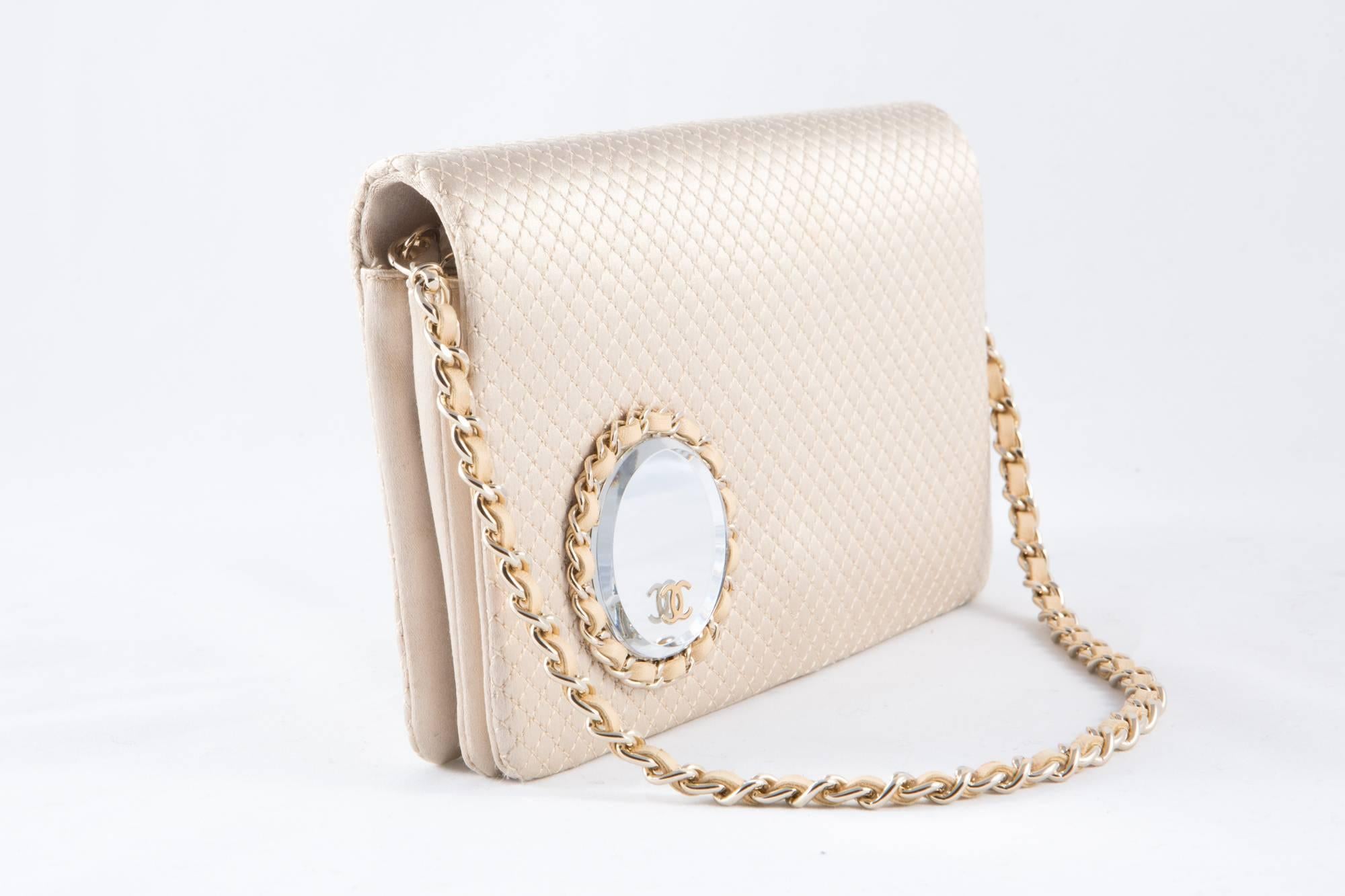 Gorgeous rare Chanel evening satin quilted clutch featuring a silver tone chain twisted with beige leather, (18,1in. (46cm) length) a front round mirror with CC gold tone logo and leather cable with silver tone chain, inside front flap in silk