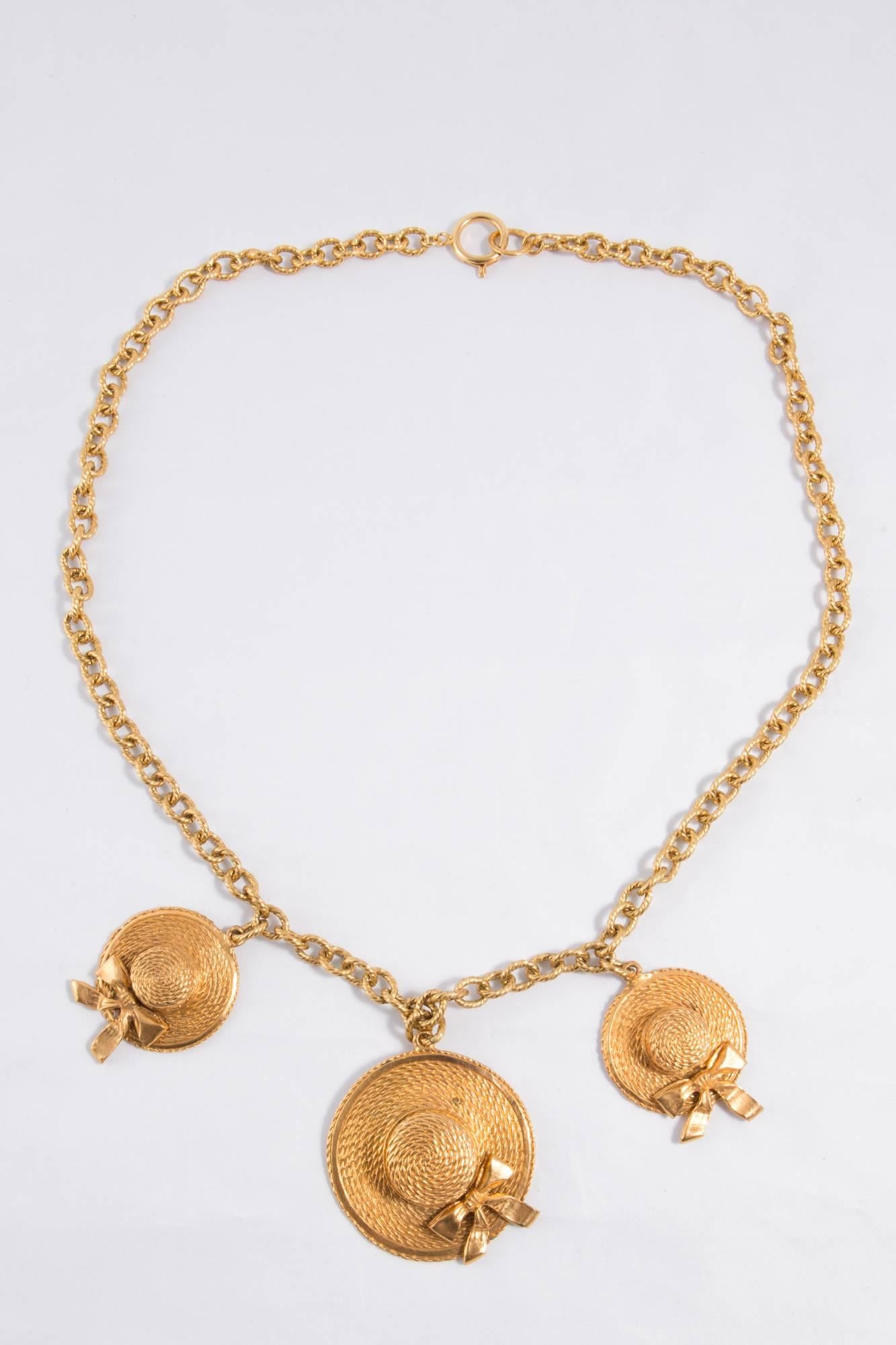 1980s iconic Chanel runaway gold tone straw hats necklace featuring 3 typical Chanel straw hats, a back Chanel plaque, a spring-ring fastening.  
In excellent vintage condition (please enlarge images to see all details on photos) 
Made in France. 