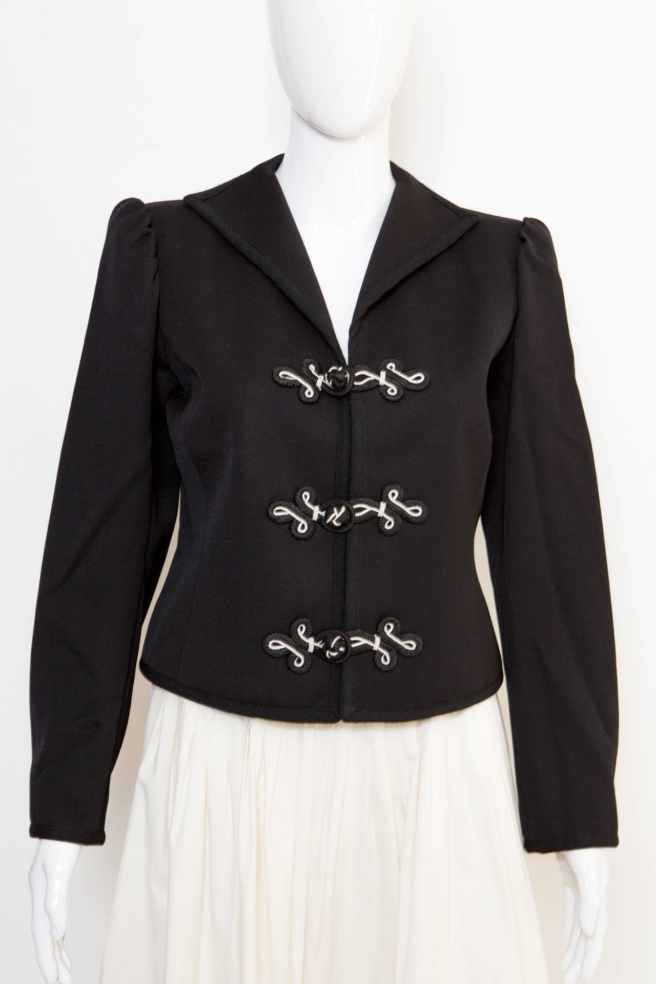Black wool jacket from Yves Saint Laurent Vintage featuring a v-neck, shoulder pads, an embroidered toggle fastening and long sleeves.
Estimated size 38 fr