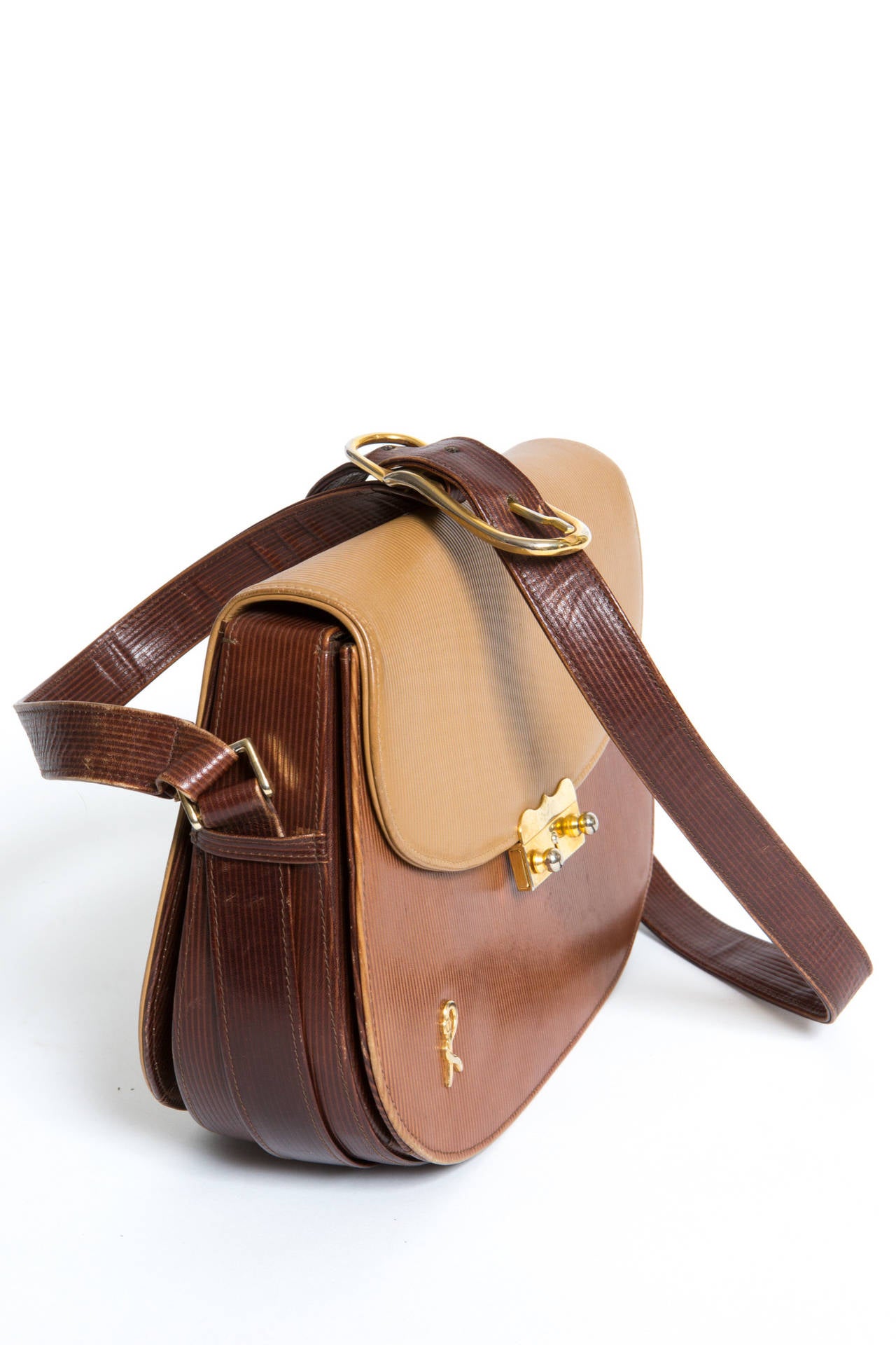 Wonderful crossbody tricolor textured leather large saddle bag from Roberta Di Camerino, adorned with the Camerino logo and a gorgeous gold-tone front clasp opening. The bag gets a long adjustable strap ( 96cm)