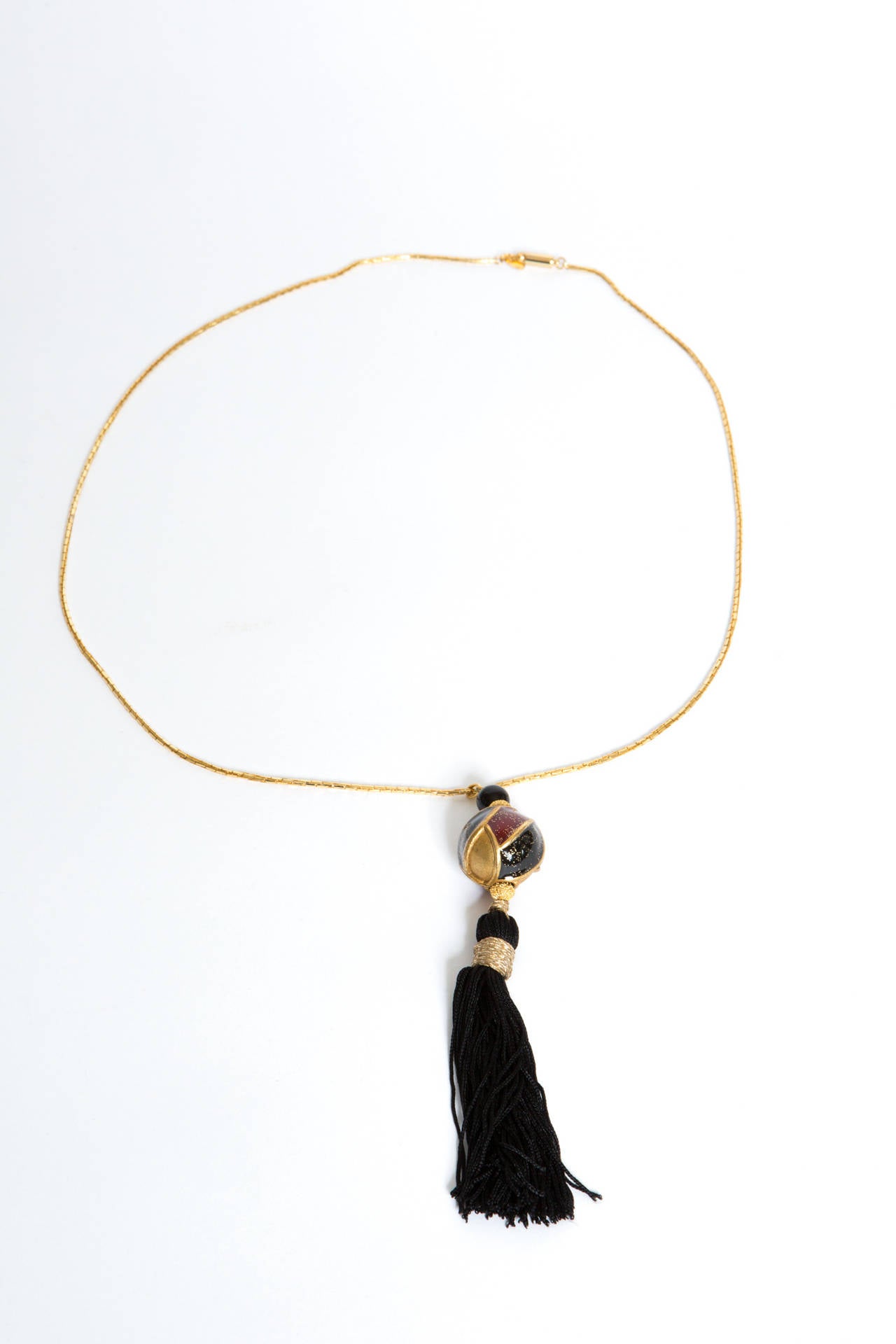 1970s Ungaro pendant necklace featuring a gold tone link chain (total lenght 78cm) and a fancy colorfull bead with a silk tassel hanging at the end (Total length bead + tassel (15cm), this necklace is marked on a plaque.