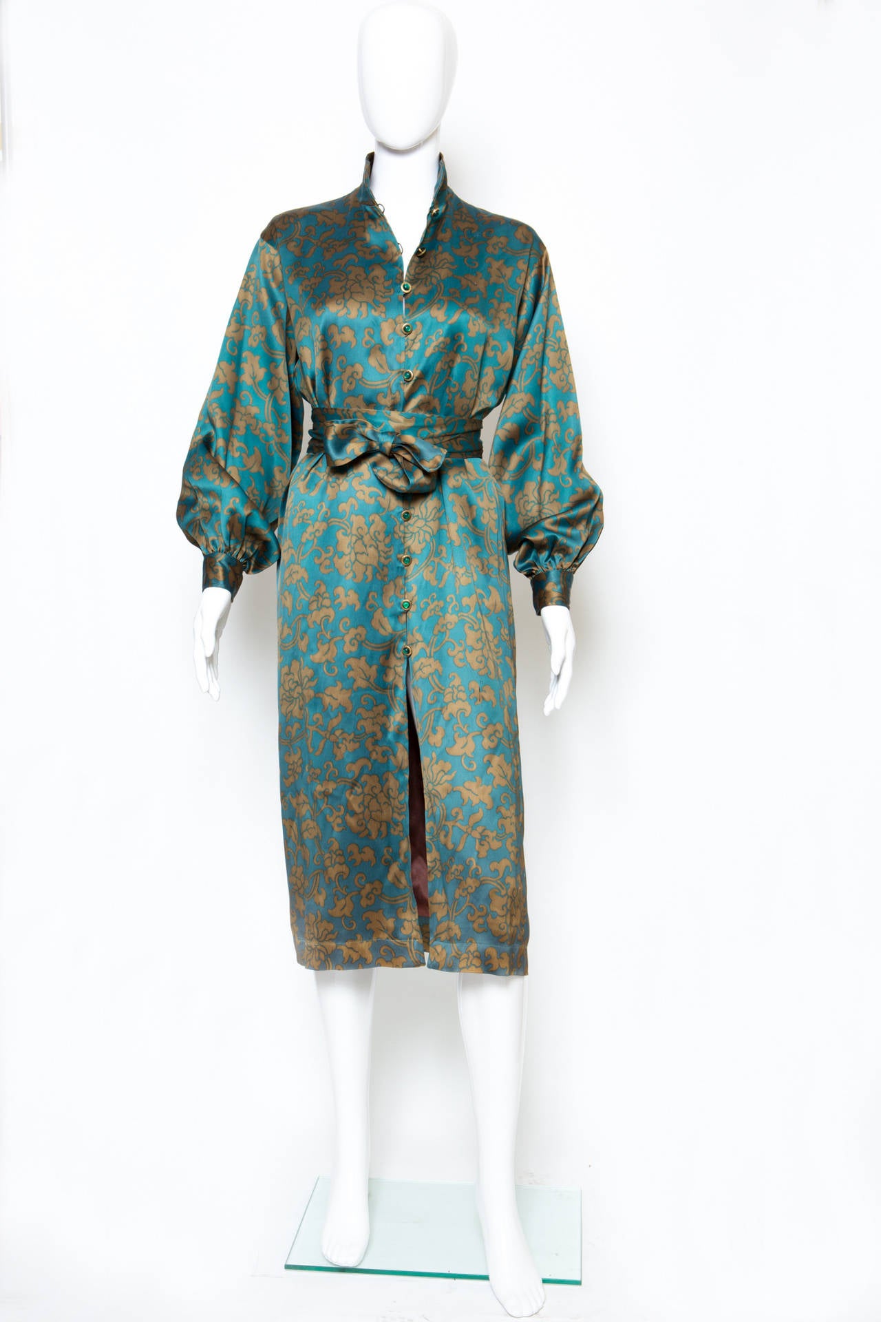 1978s Yves Saint Laurent printed silk satin dress fully front opening with fancy jewel buttons and loops, flouncy cuffs with two matching fancy jewel buttons. The dress has a fully brown silk lining, and a seperated belt: 197cm x  6cm.
Estimated
