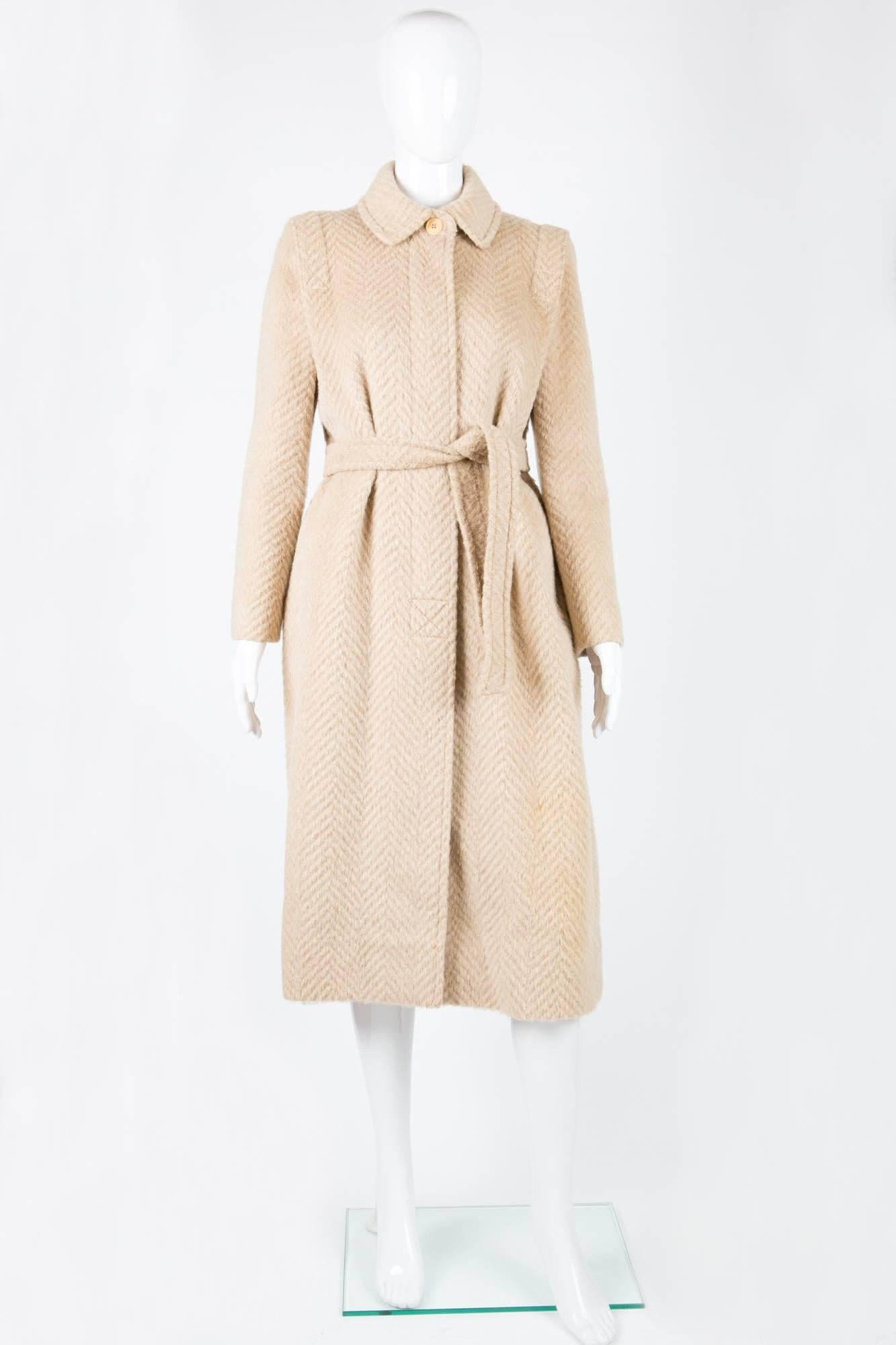 Fabulous Louis Feraud cream coat featuring an herringbone cream pattern, long sleeves, side seams pockets, detachable belt, logo silk lining, shoulder details.
In excellent vintage condition. 
Accrocs shoulder 15,3 in. (39cm)
Chest 33,8in. (