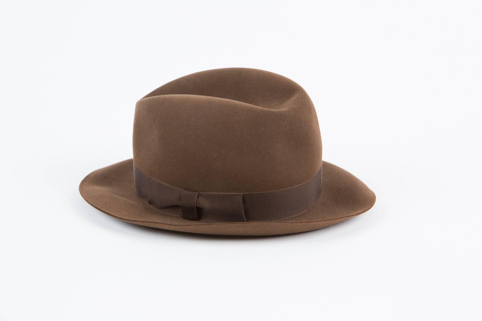 Brown chocolate wool grosgrain band Hermès fedora hat featuring a darker brown grosgrain bow at the centre. 
Border width: 2,3in. (6 cm)
Inside size label 55. 100% wool. 
In excellent vintage condition. Made in France.