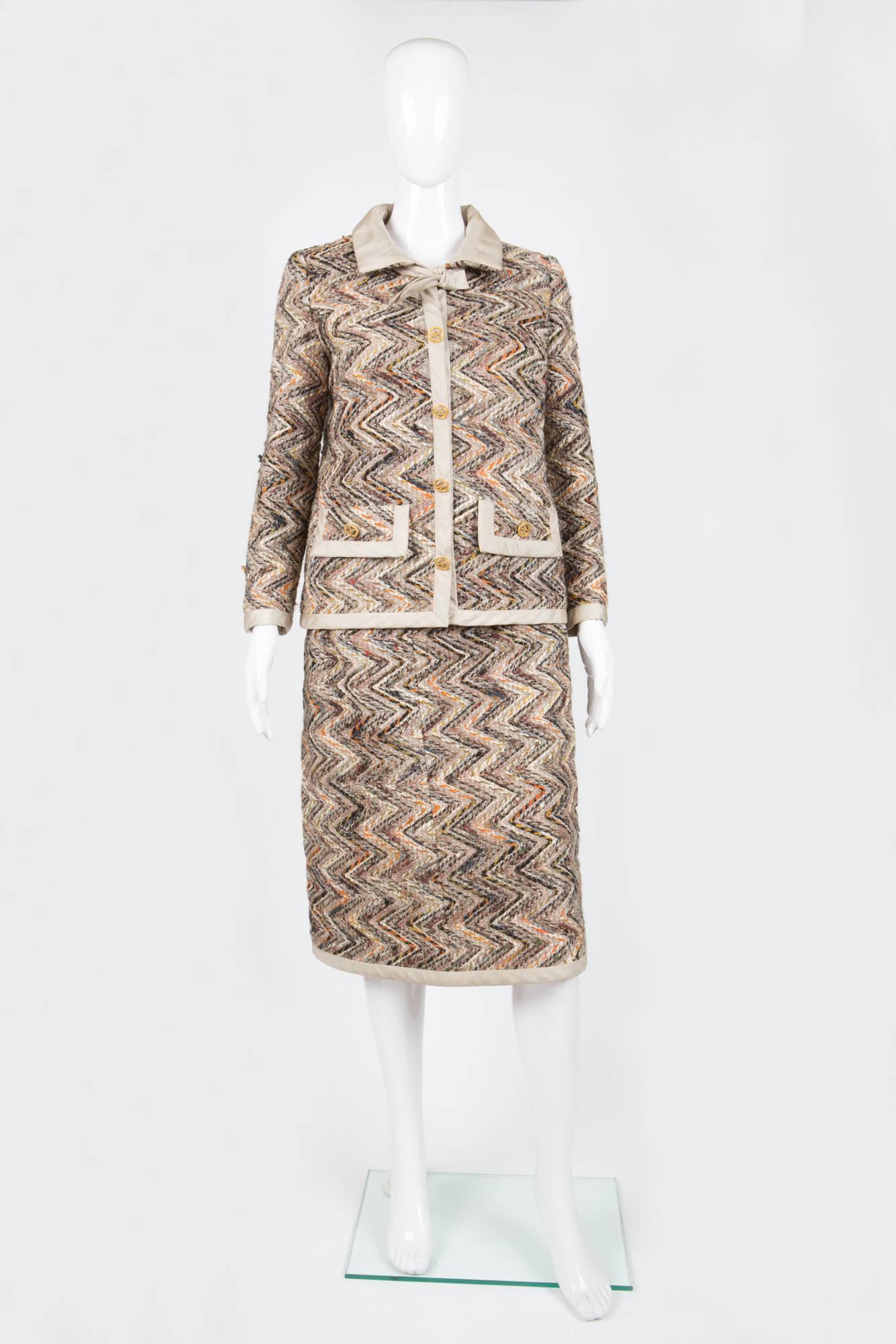 1960s rare Haute Couture Chanel tweed suit featuring a zebra wool tweed jacket  with light ivory silk details, decoratives gold tone buttons (with hidden silk recovered snaps), light orange silk lining, a matching wool & silk skirt. 
In good vintage