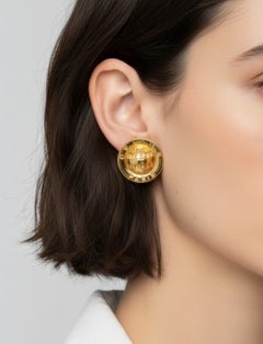 Celine – Rund geformte Clip-Ohrringe mit Logo in Goldoptik