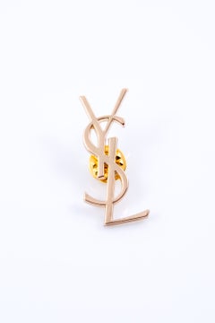 Grande broche « YSL » Cassandre de couleur dorée signée Yves Saint Laurent