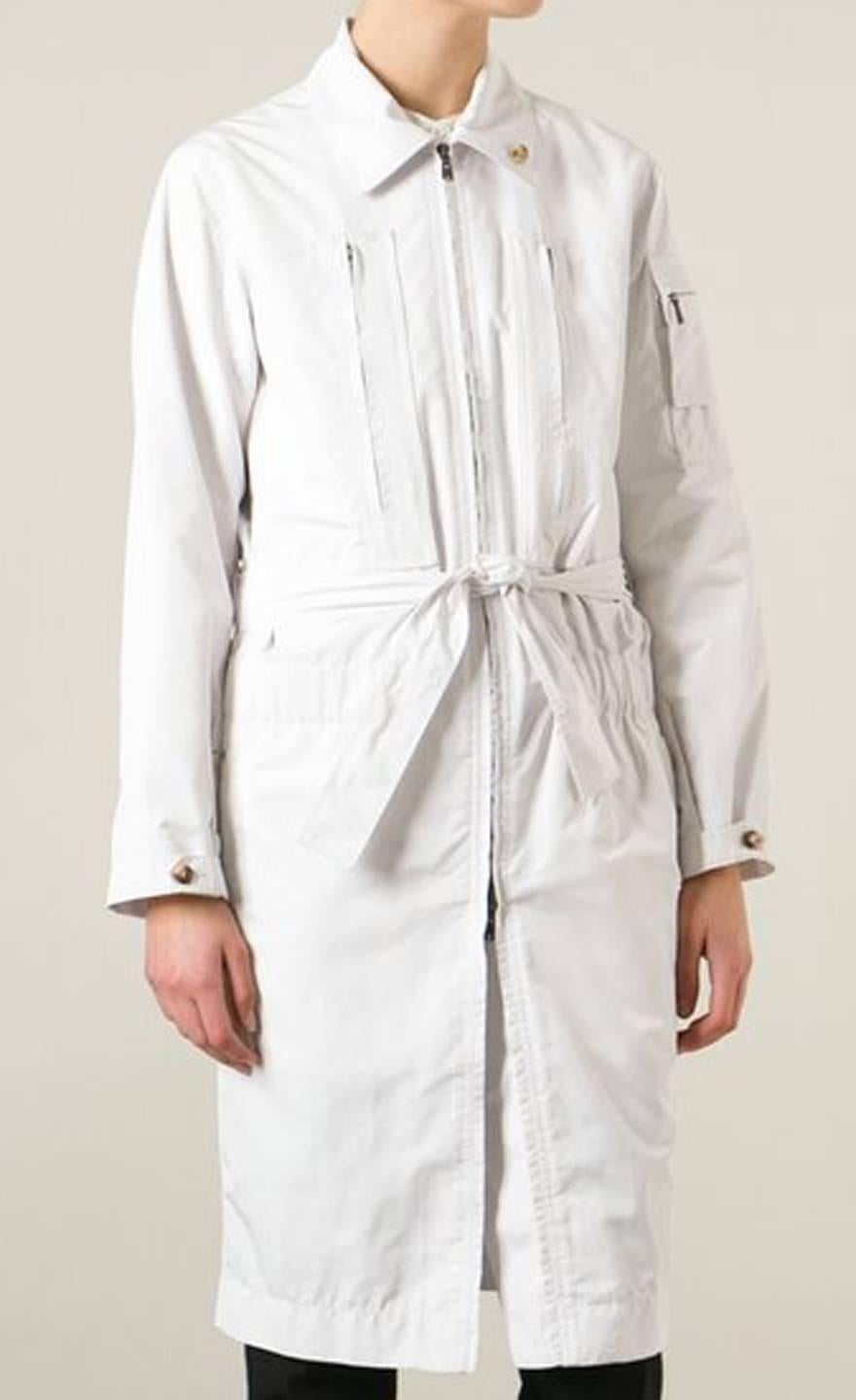 White Saint Laurent trench coat  featuring a center front zip opening, a classic collar, long sleeves, an elasticated waistband, a belted waist, side zipped pockets and a mid-length.
In excellent vintage condition. Made in France. 100%