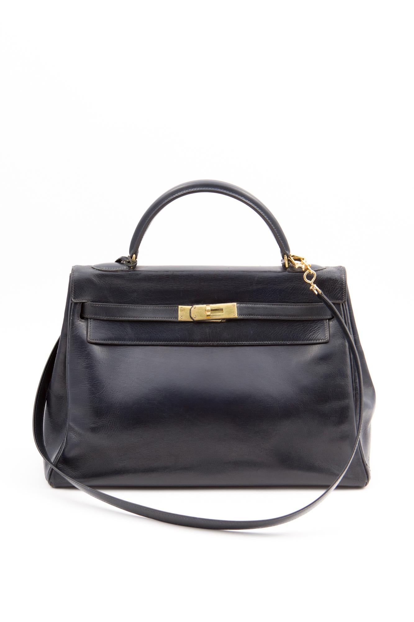 1960-1970s Hermès dark navy box calf leather Kelly tote bag 32cm featuring foldover top with twist-lock closure, a top handle, a trapeze body, plated-gold hardware, an internal slip pocket, a clochette, and a detachable box calf shoulder strap