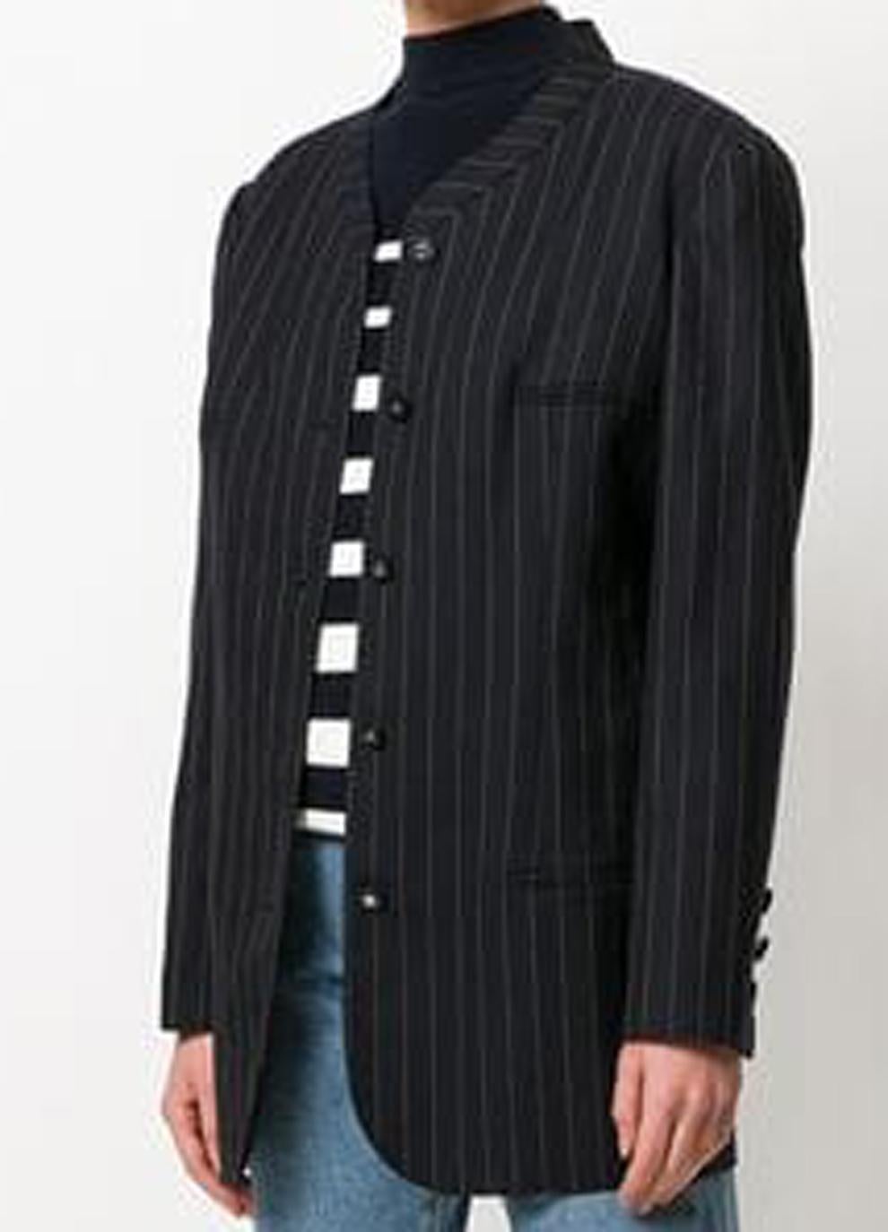 Black Chanel pinstripe long length jacket featuring a band collar, a front button fastening, long sleeves, button cuffs, a full silk lining, a straight hem and CC logo buttons. 
Composition: 100% wool
In excellent vintage condition. Made in