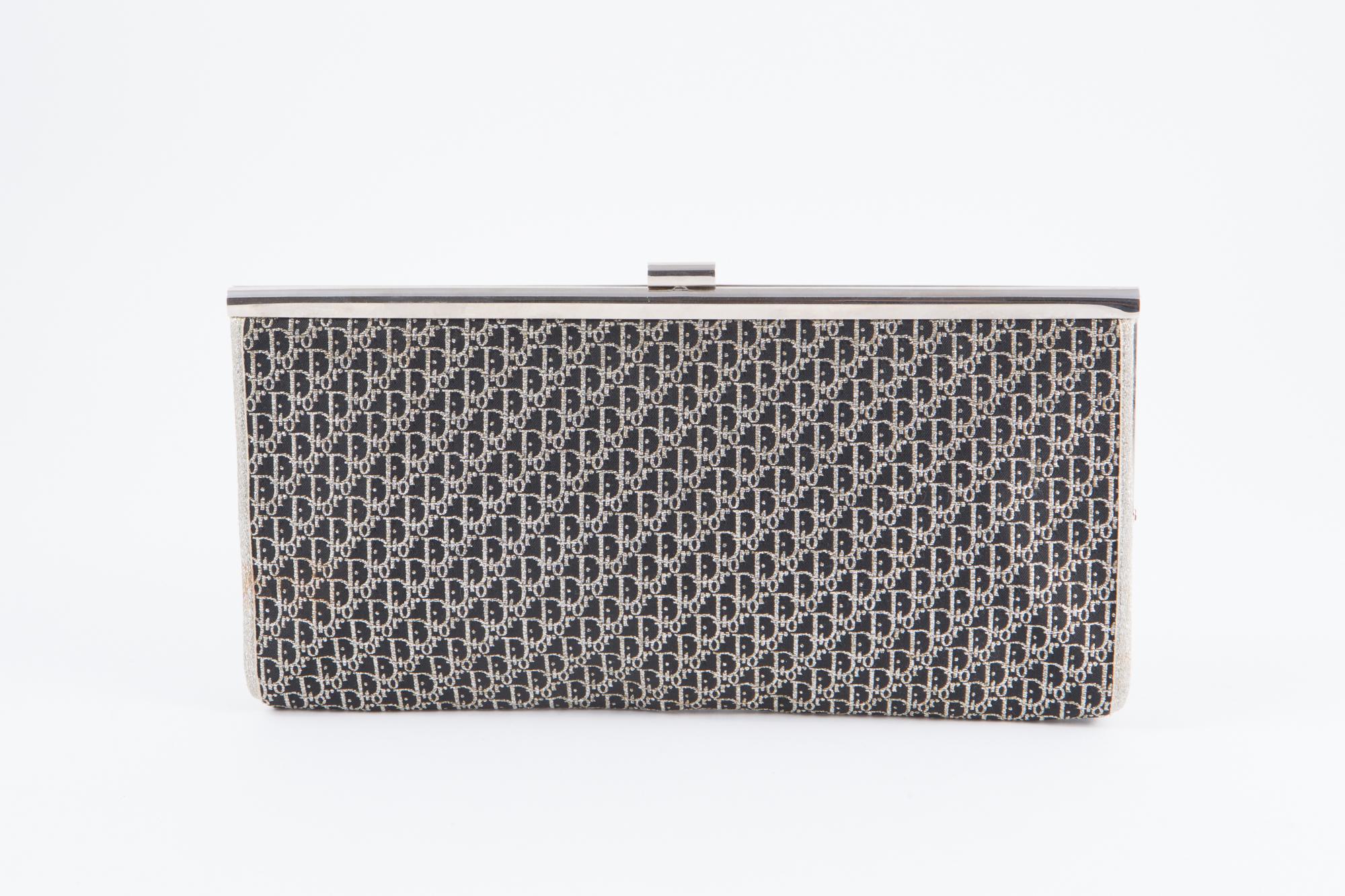 1970s Dior black cotton canvas monogram logo clutch featuring an all over logo pattern with silver tone lurex, silver tone hardware, an inside logo stamp. 
Width 11in (28cm)
Height 5.5in. (14cm)
Depth 1.5in. (4cm)
In excellent vintage condition.