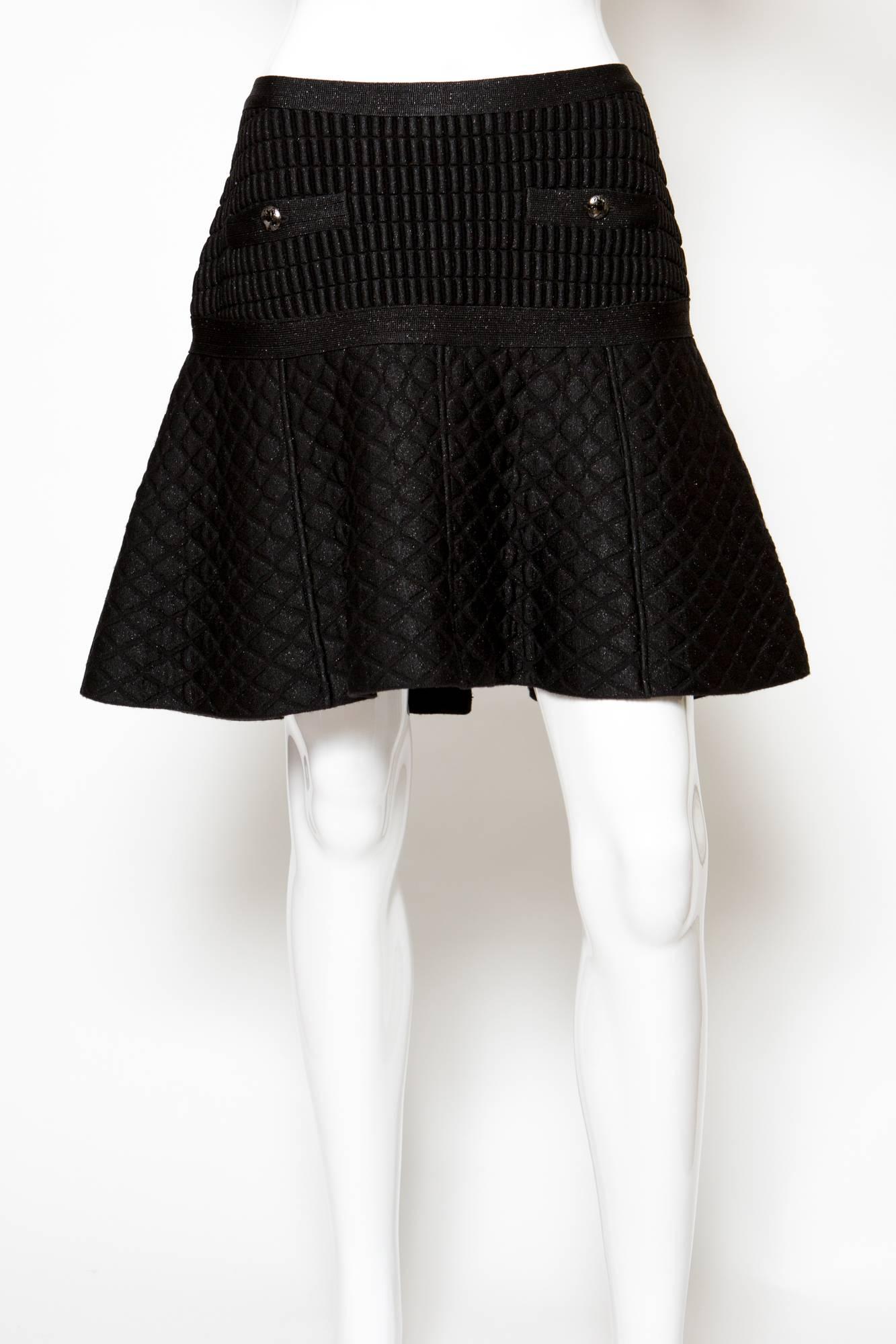 Chanel short black skirt skater featuring a center back zip, front pockets with decorative buttons, a fancy mix wool and polypropylene textured fabric. 
Label size Chanel: 38fr
Estimated size: 36fr
