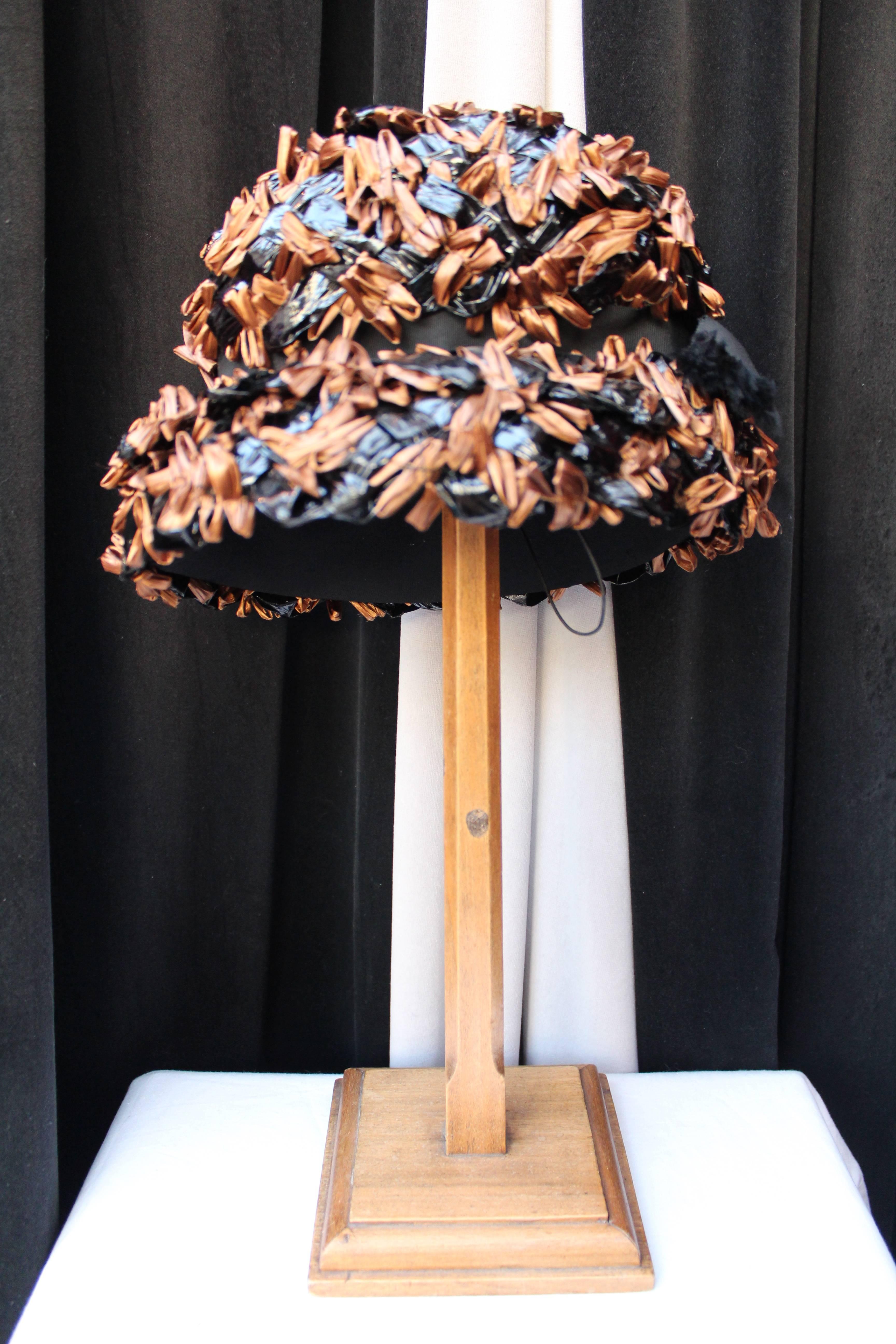 SCHIAPARELLI PARIS Hat composed of black silk and tulle covered with synthetic raffia in black and tobacco brown colors, adorned with a black ribbon bow at the rear. 

Gorgeous hat from the 1950s. 

Very good condition. 

Measurements: 
Size