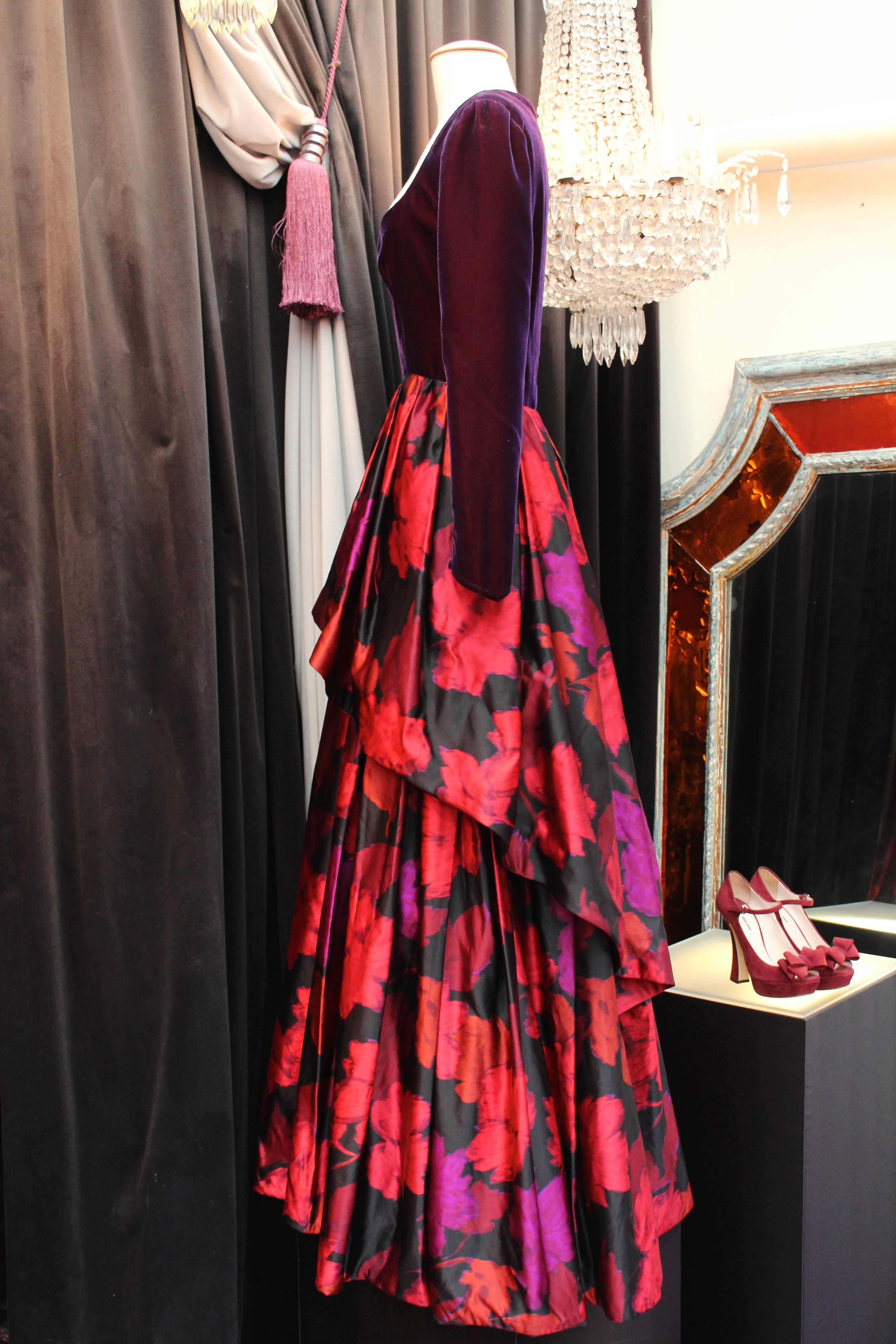 LAPIDUS HAUTE COUTURE (Paris) Evening gown composed of a long sleeves top in velvet plum color and a long printed silk taffeta skirt with a plum, red and fuchsia floral motif.

The magnificient flared skirt, longer at the rear, is constructed with